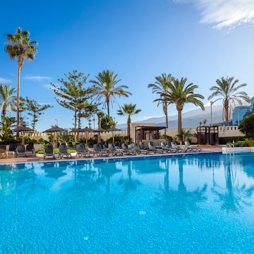 a pool with chairs and trees