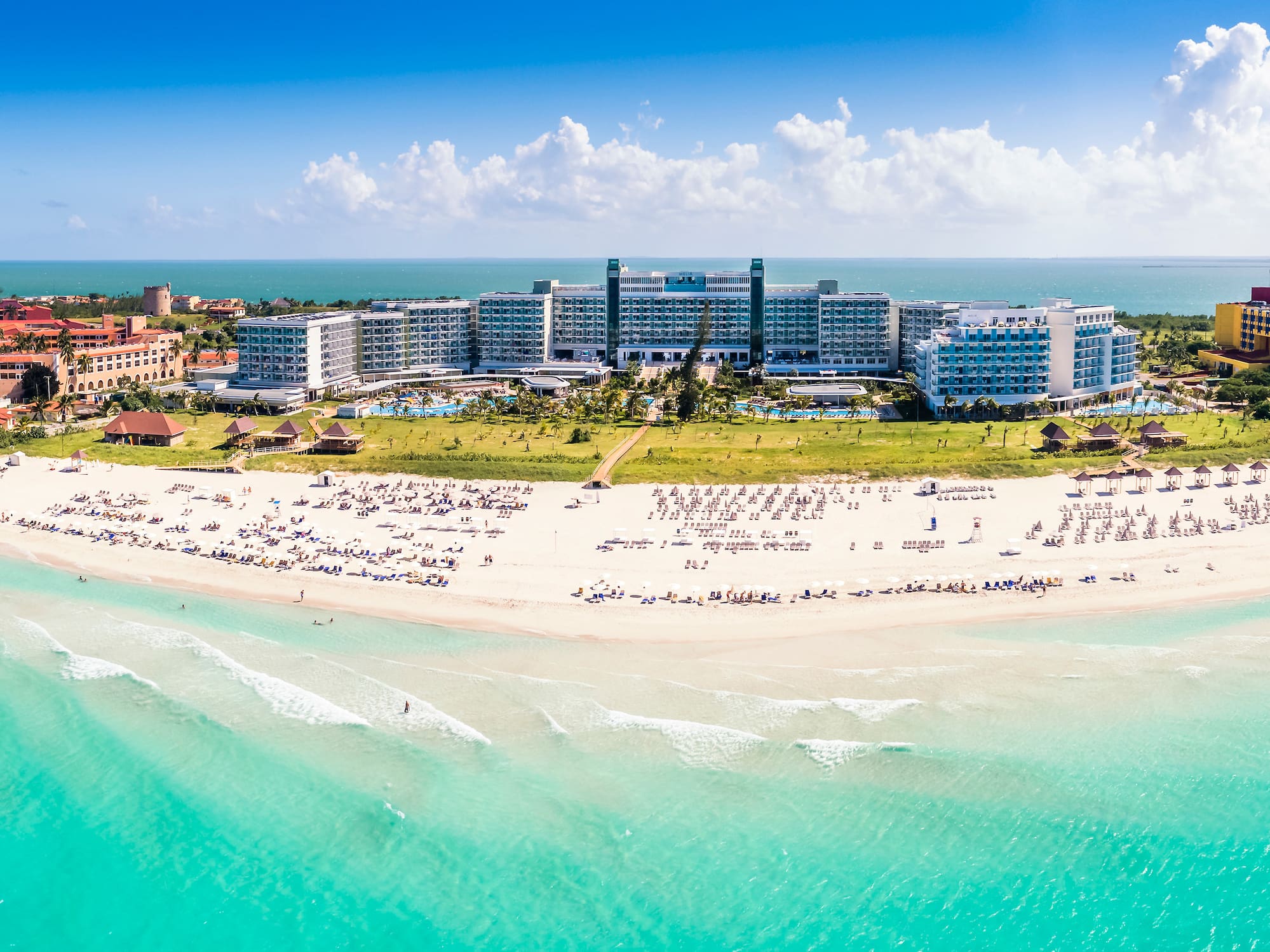 a beach with many people and buildings