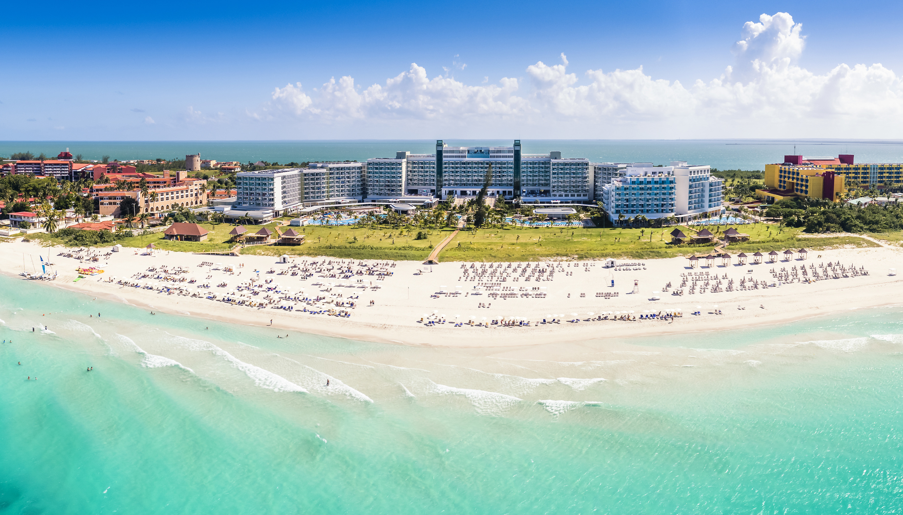 a beach with many people and buildings