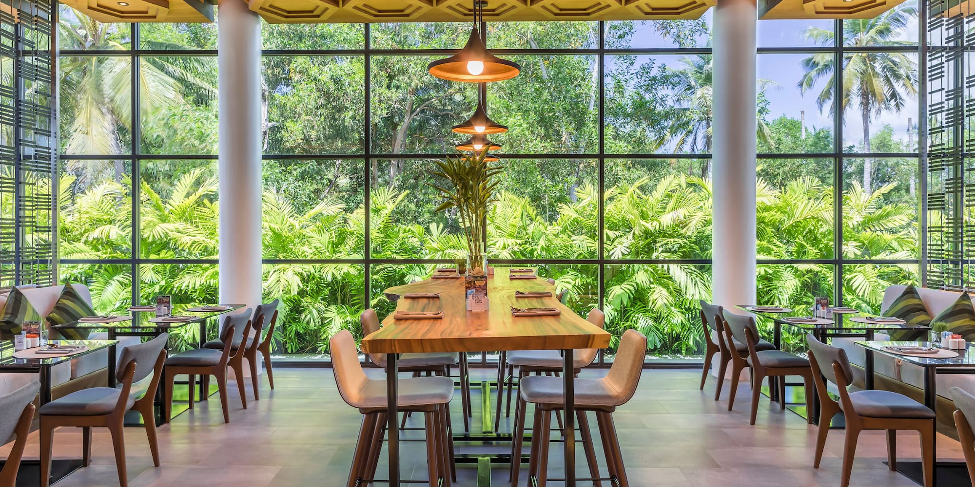 a room with a large window and tables and chairs