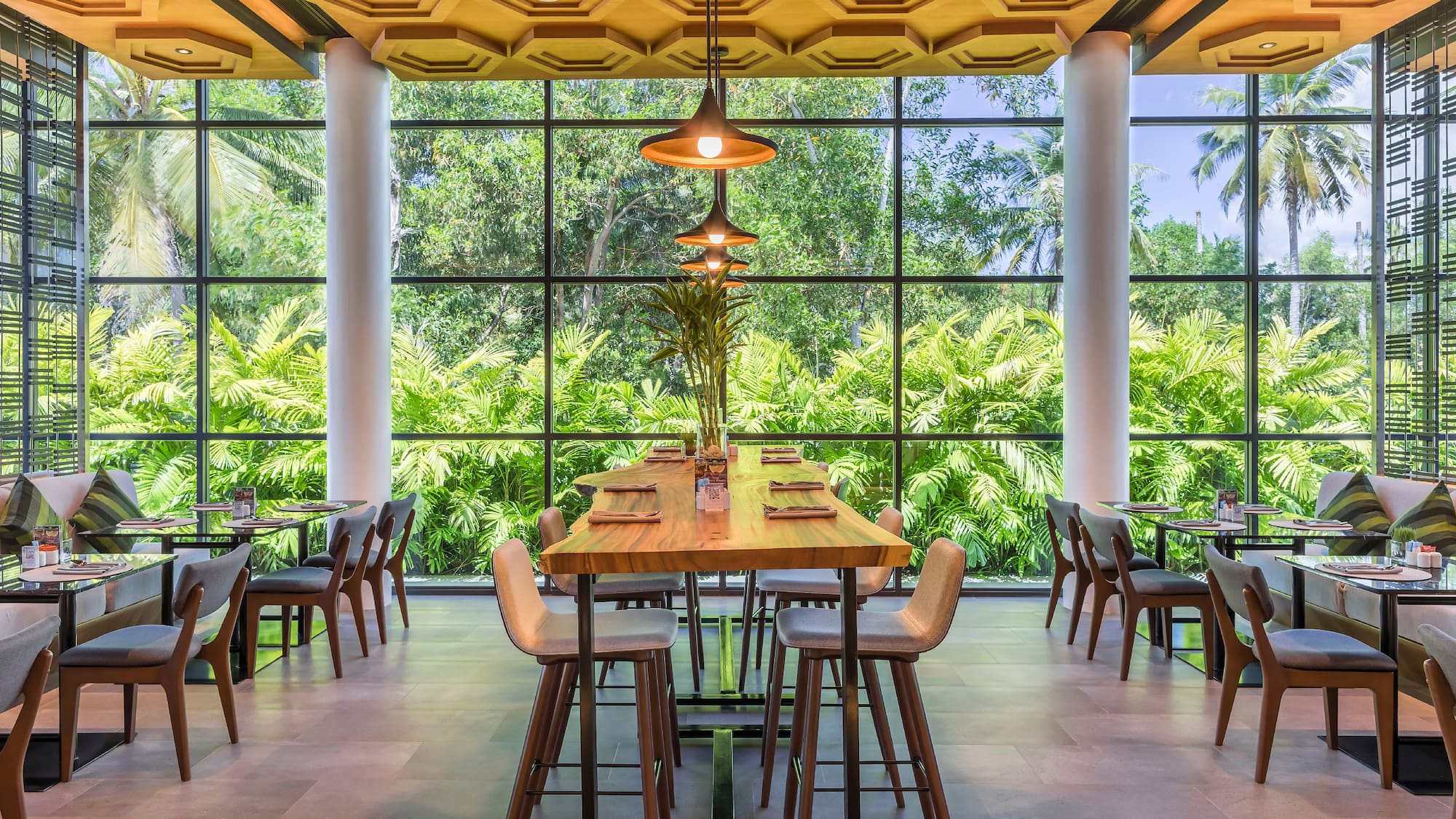 a room with a large window and tables and chairs