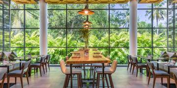 a room with a large window and tables and chairs