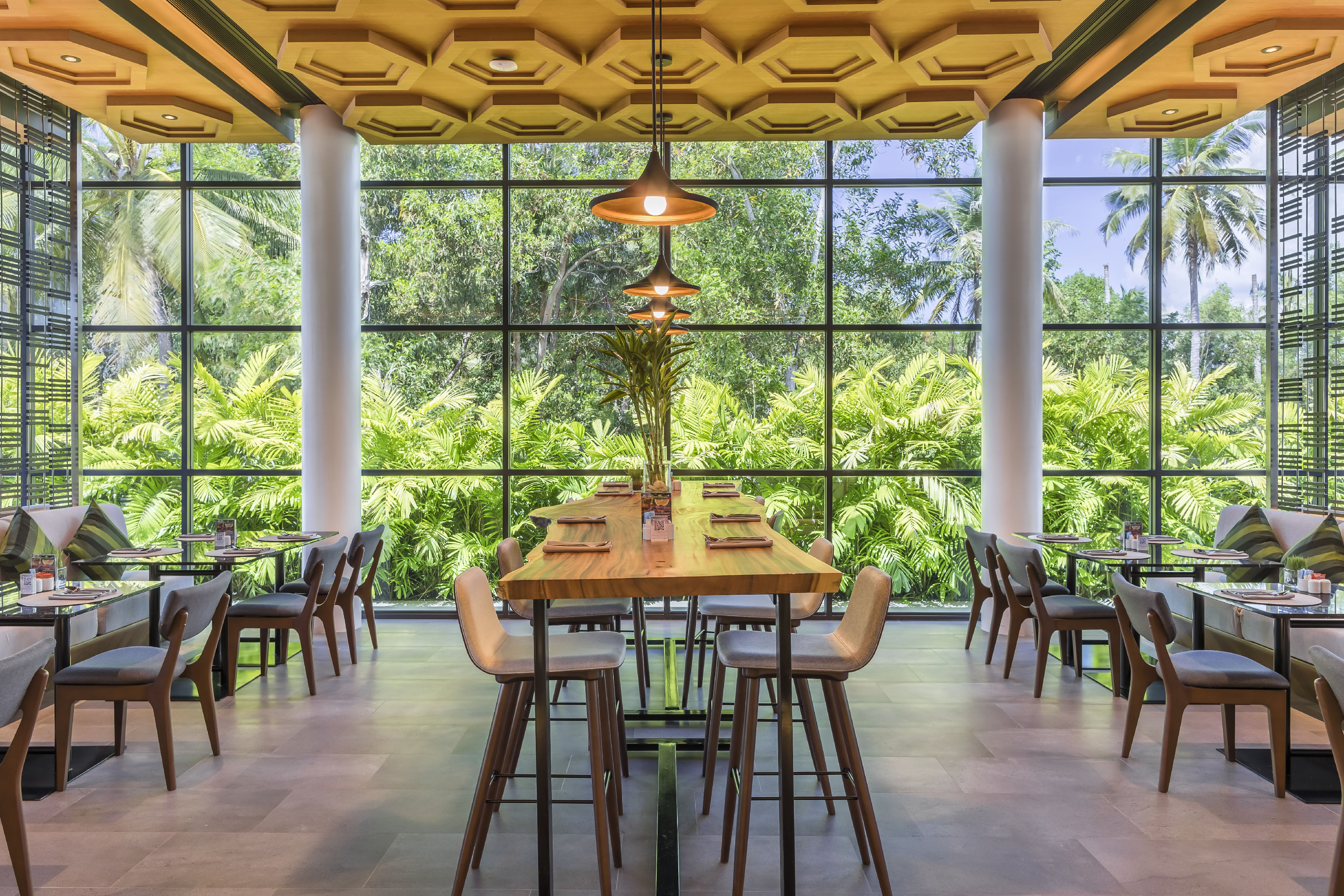 a room with a large window and tables and chairs