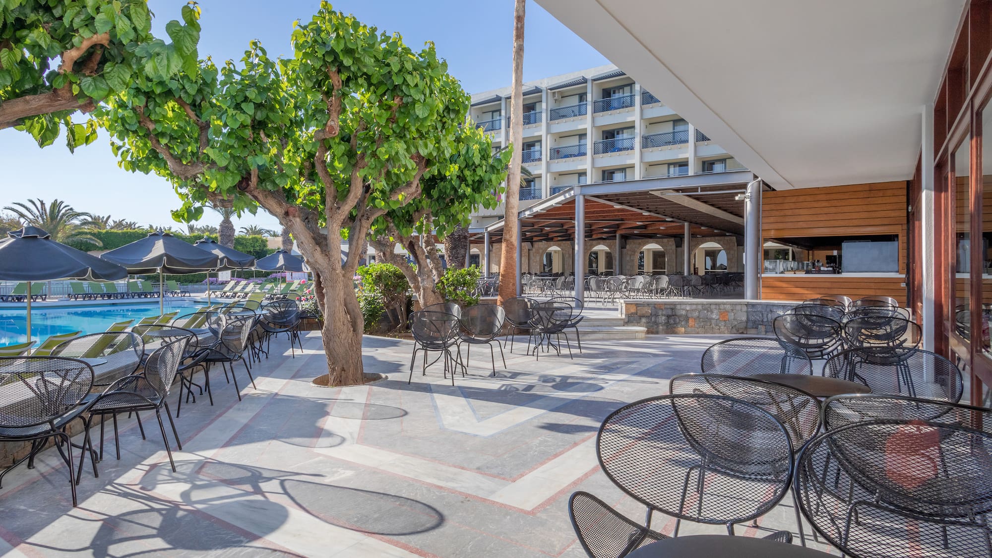 a patio with tables and chairs and trees