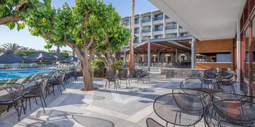 a patio with tables and chairs and trees