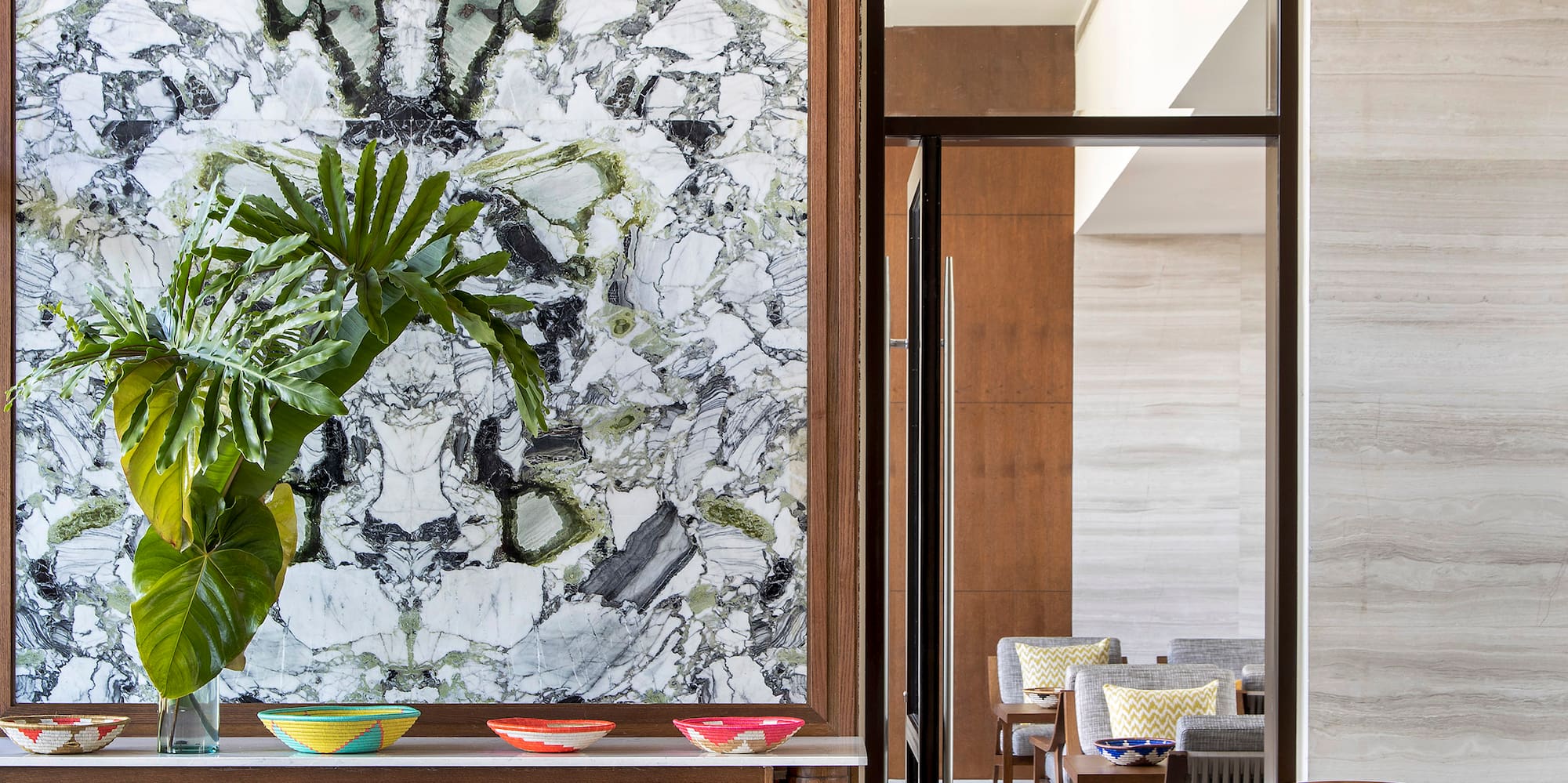 a room with a marble wall and a plant