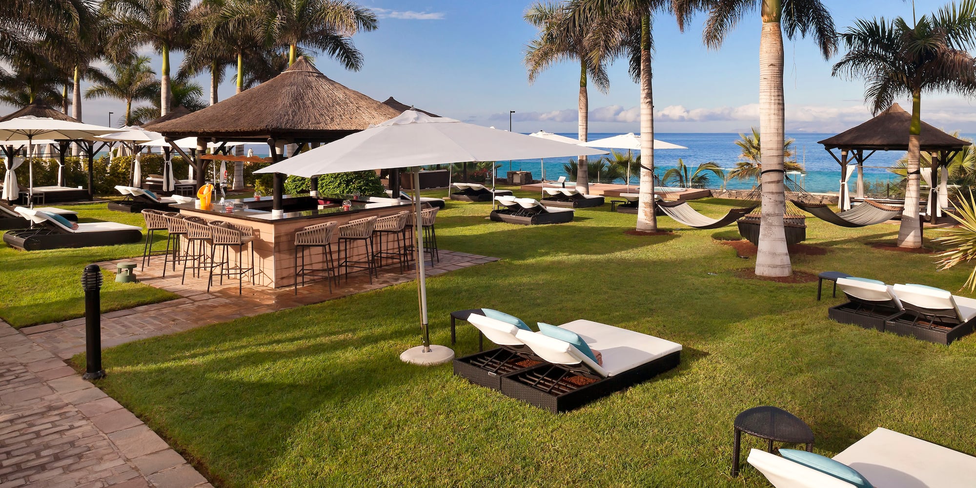a beach bar with chairs and umbrellas