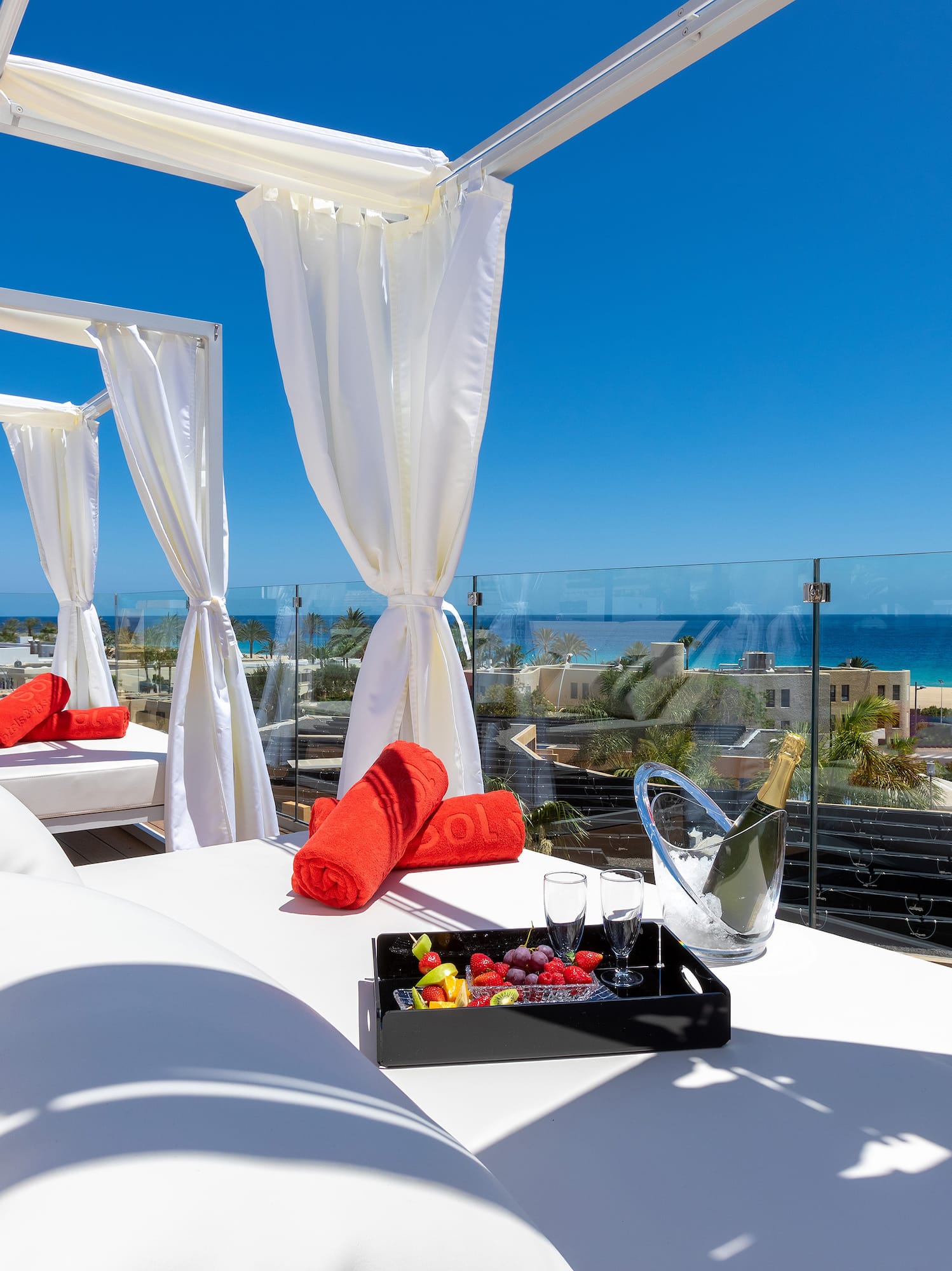 a white canopy with white curtains and towels on it