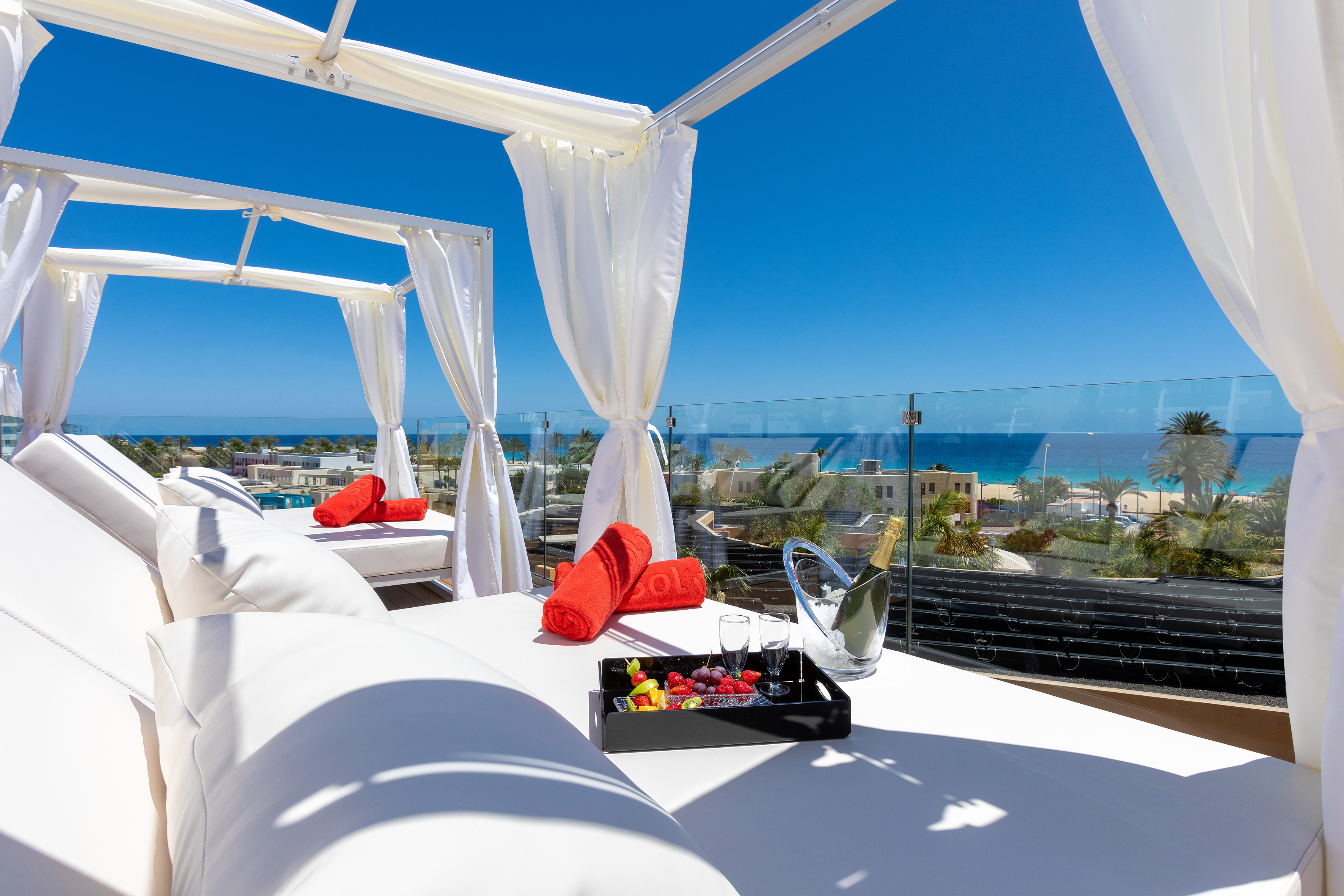 Luxury resort cabana with ocean view, fruit, and champagne.