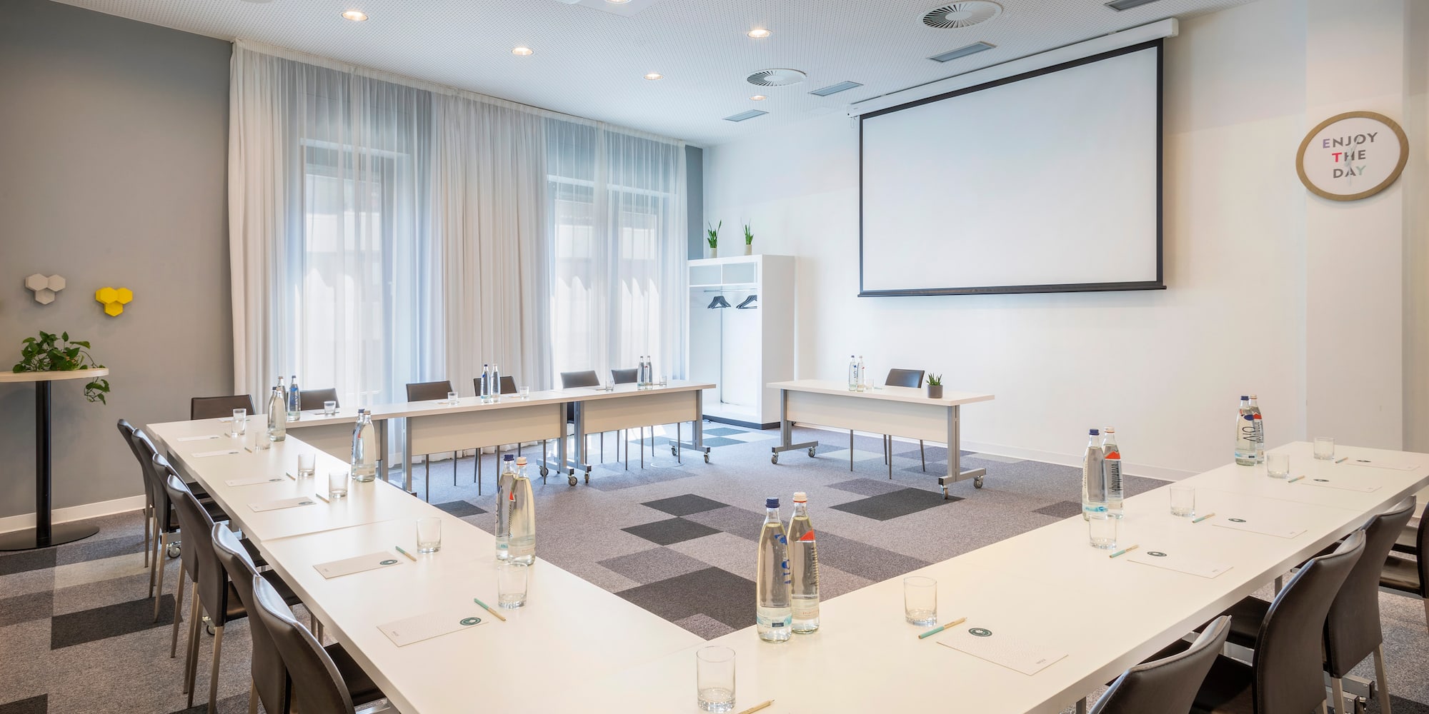 a room with tables and chairs and a projector screen