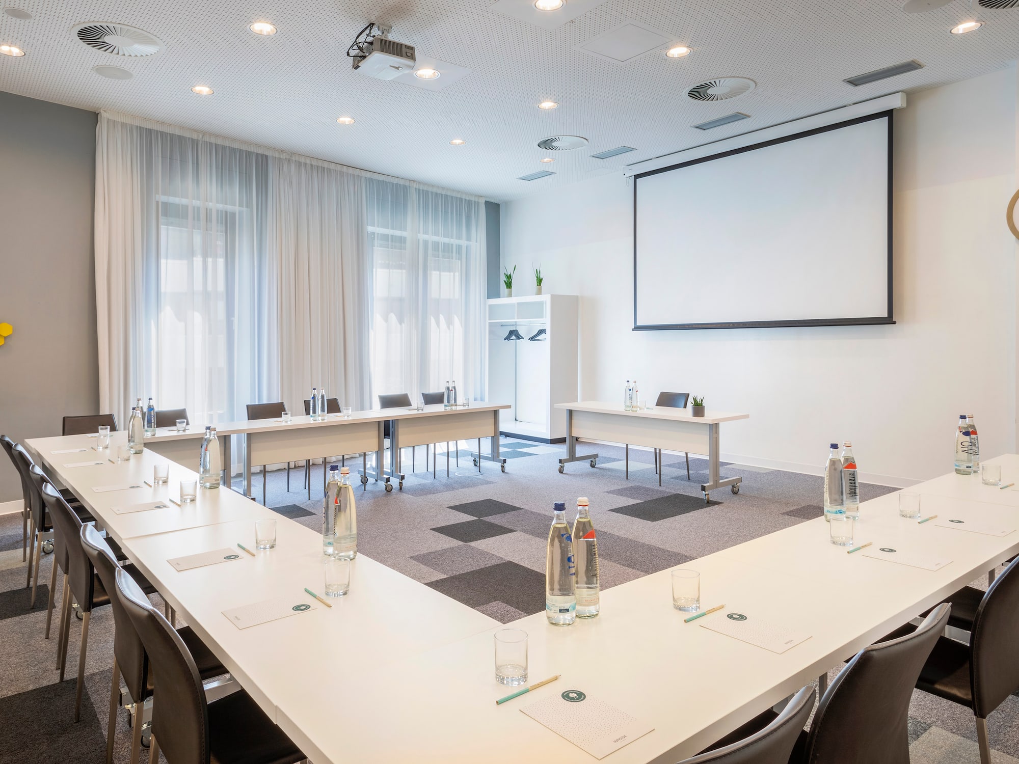 a room with tables and chairs and a projector screen