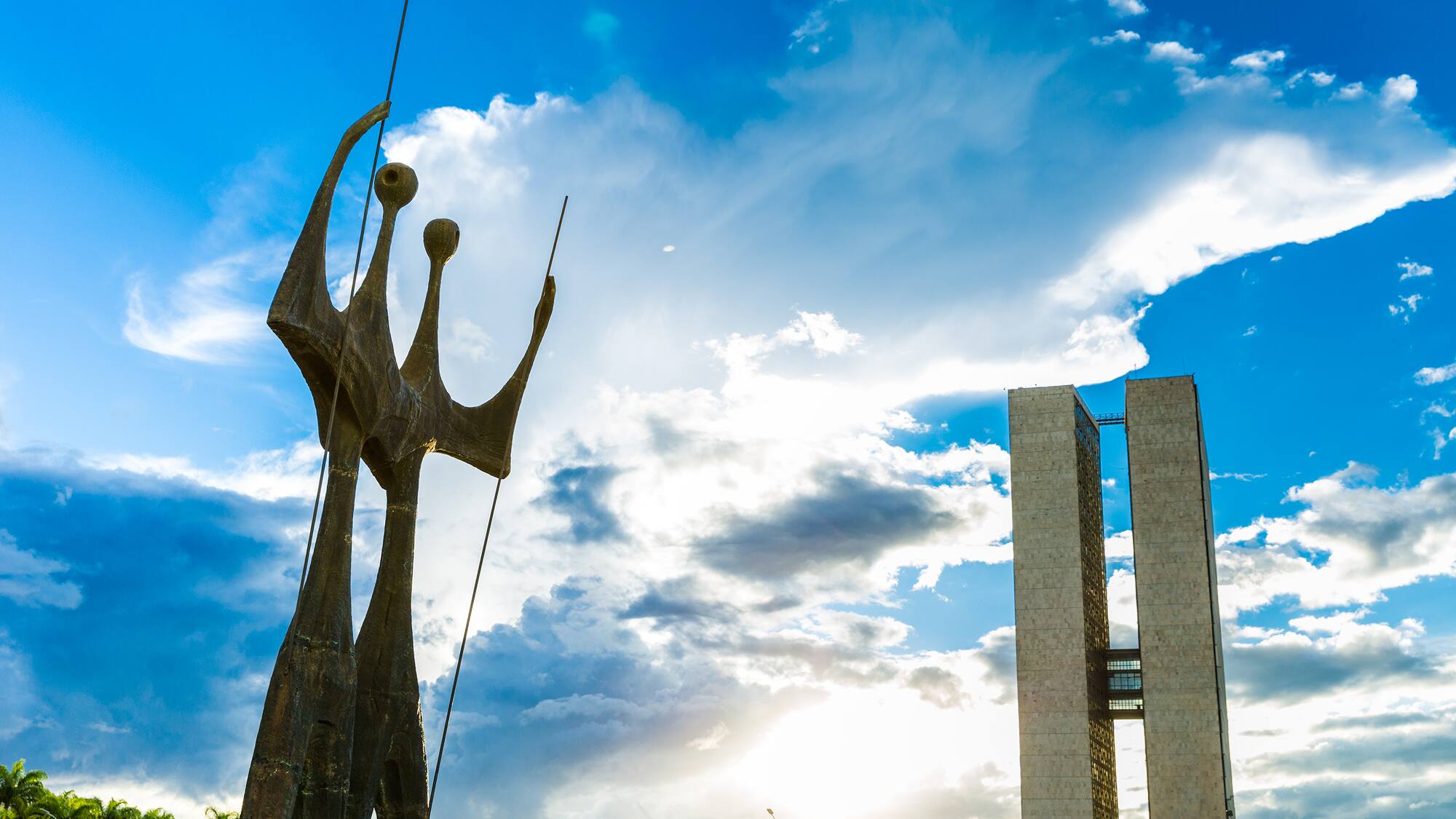 a statue of a man with a long tail and a tall tower