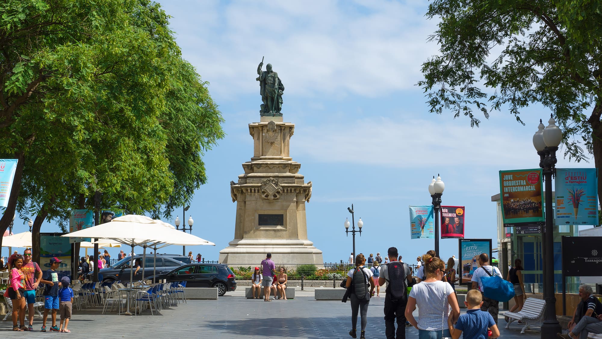 a group of people walking around a statue