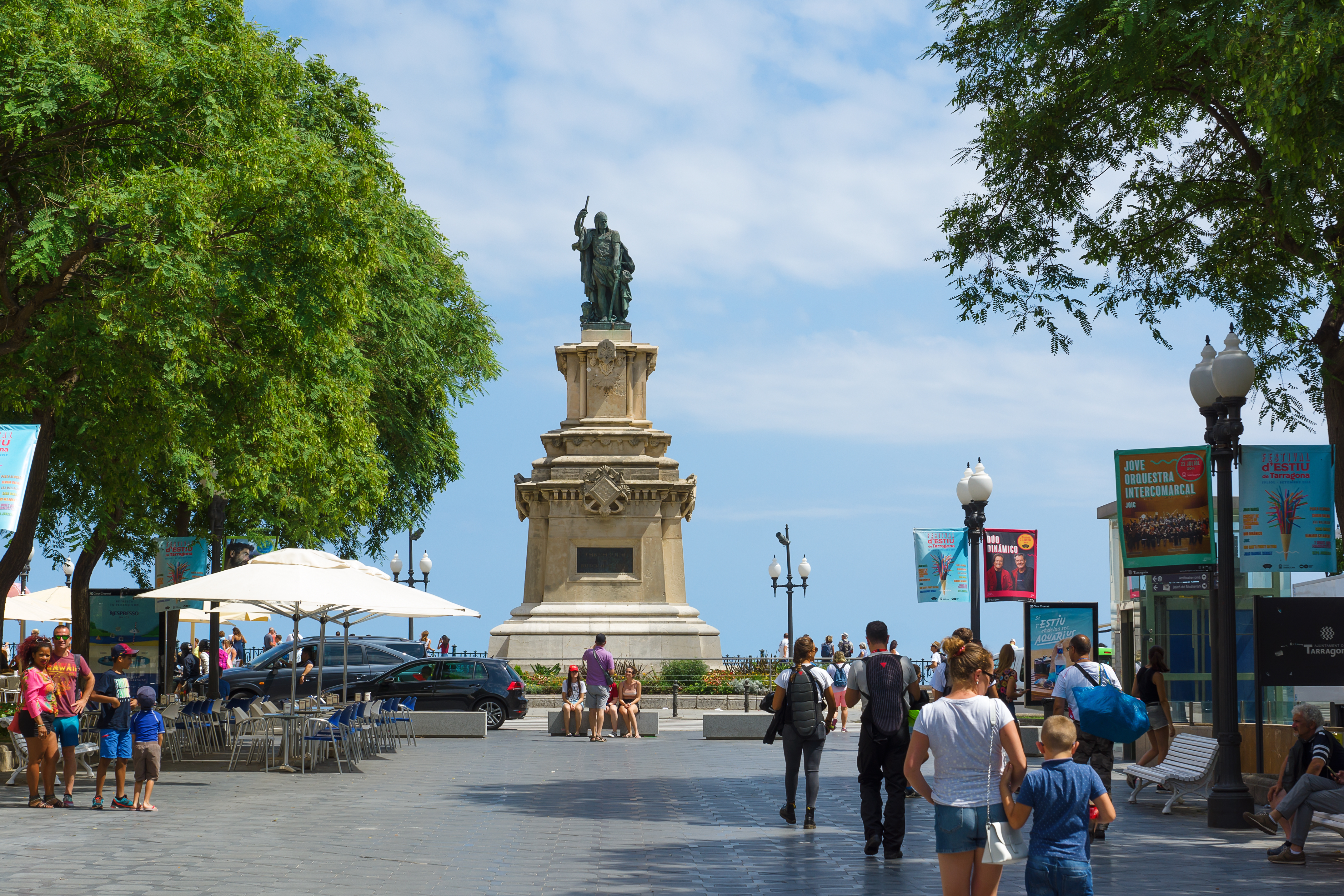 a group of people walking around a statue