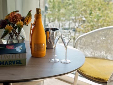 a table with wine glasses and a bottle on it