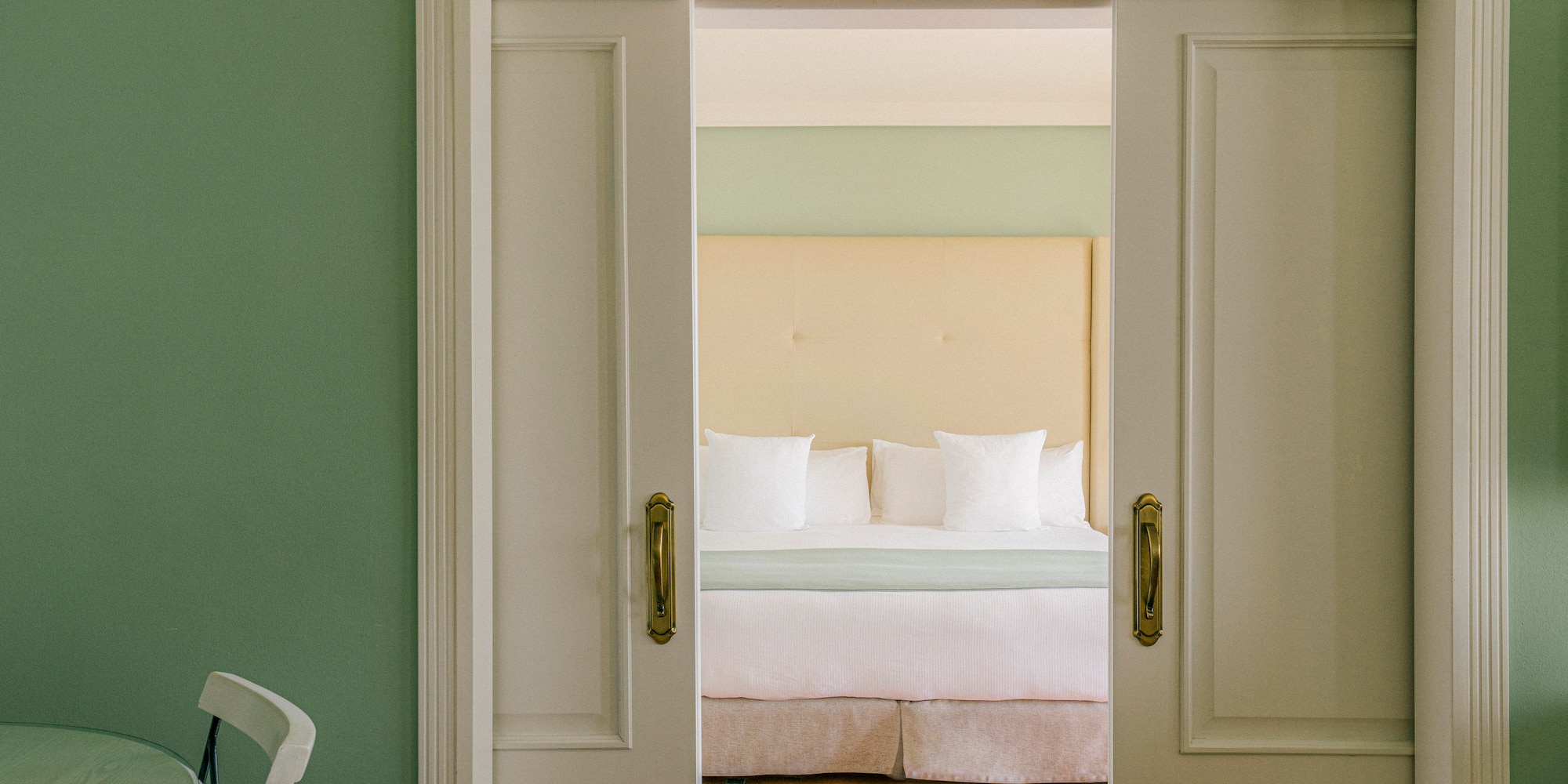 a door with a bed and a chair in the background