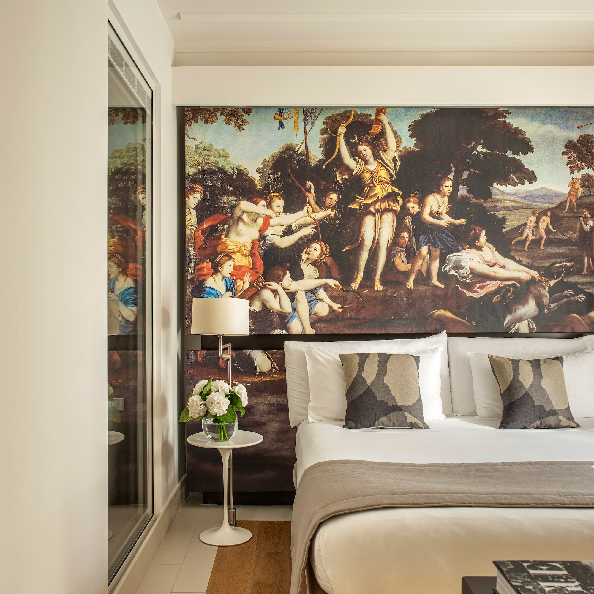 a bed with a large painting on the wall