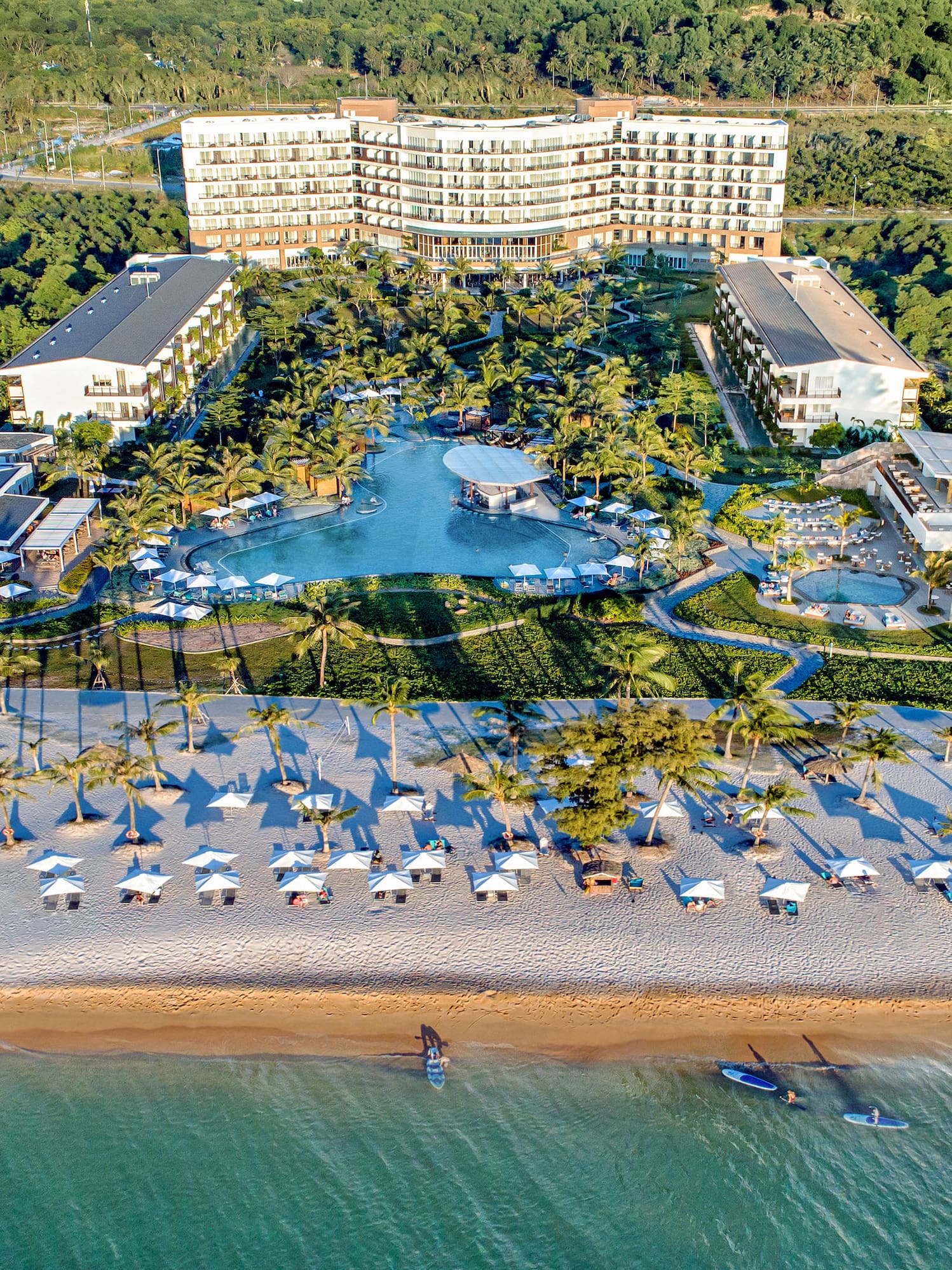 a beach with a large building and a pool