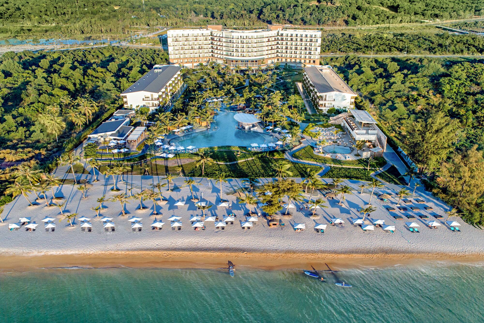 a beach with a large building and a pool