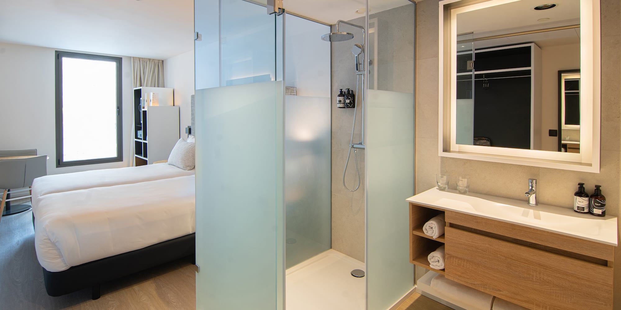 a bathroom with a glass shower and a bed