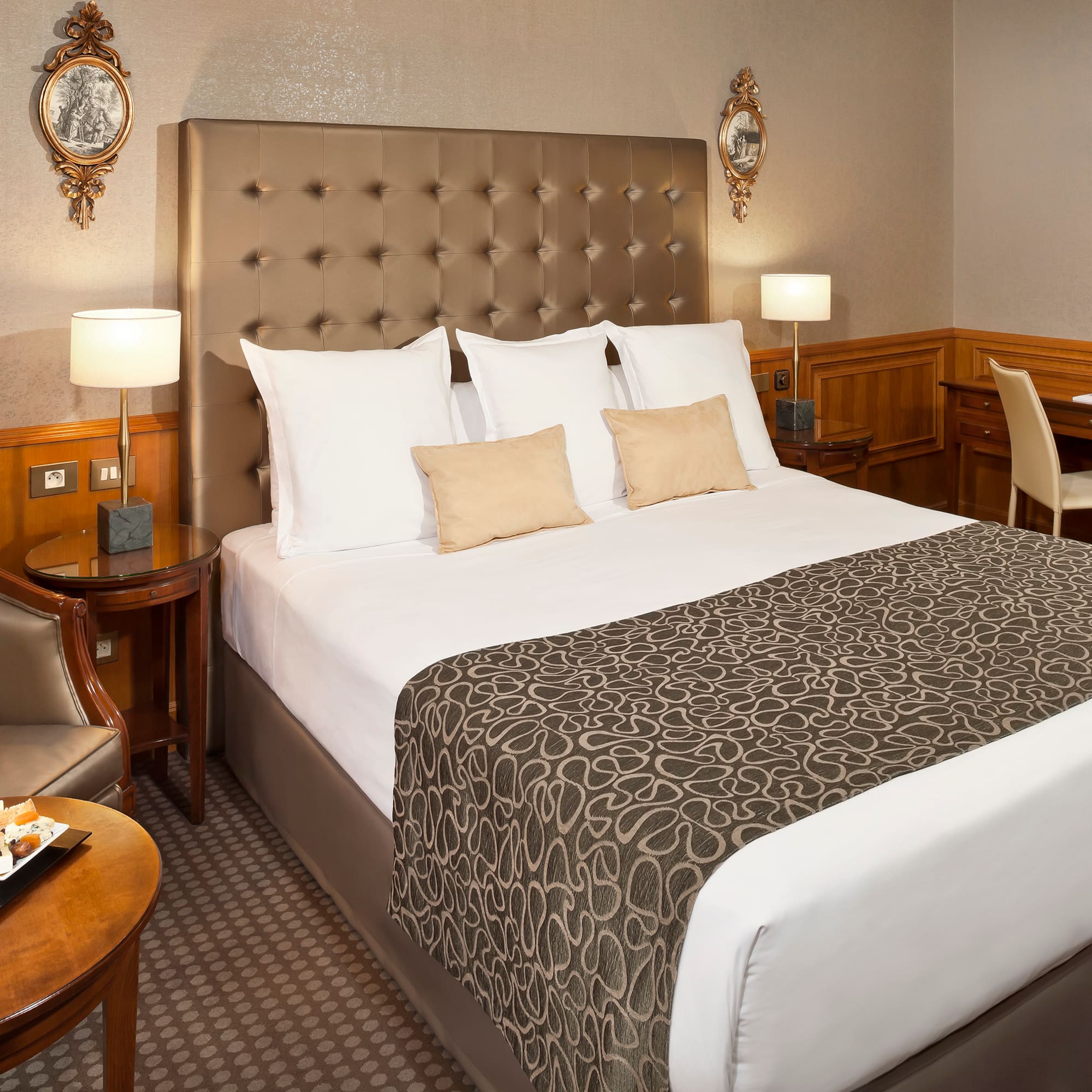 a bed with a headboard and a table with a tray and chairs