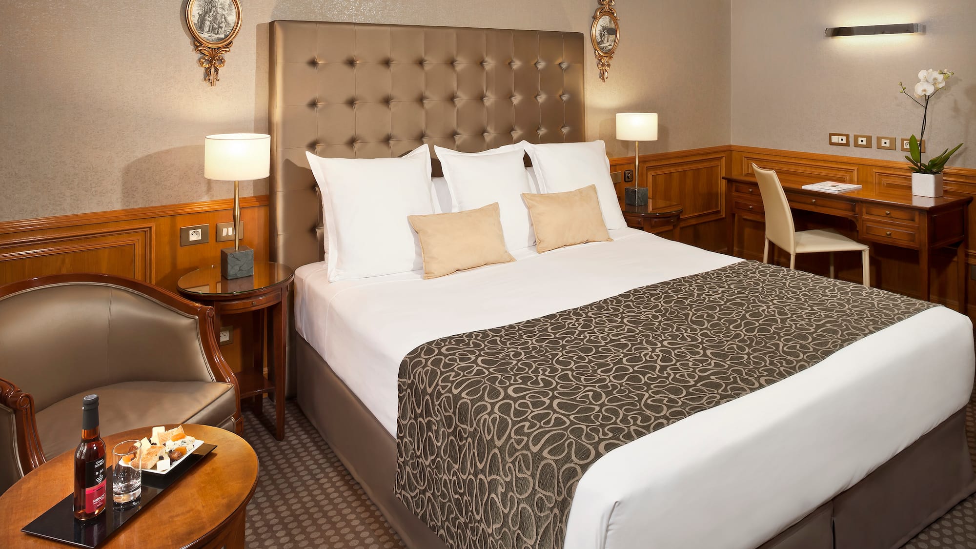 a bed with a headboard and a table with a tray and chairs