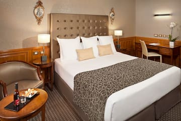 a bed with a headboard and a table with a tray and chairs