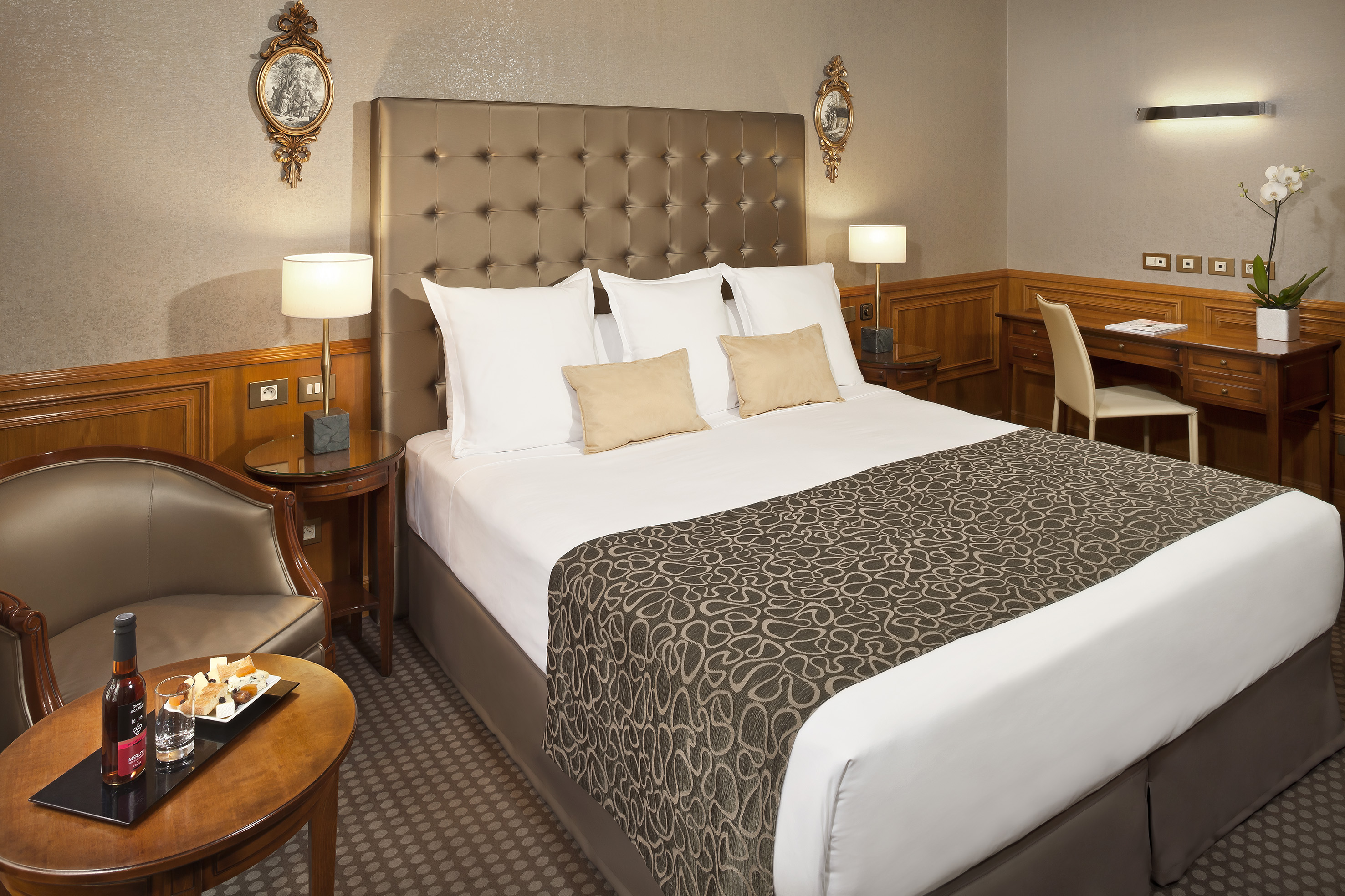 a bed with a headboard and a table with a tray and chairs