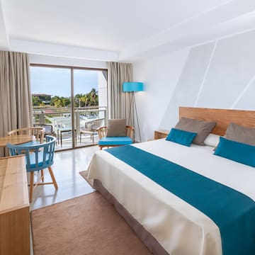 a bedroom with a bed and a table and chairs