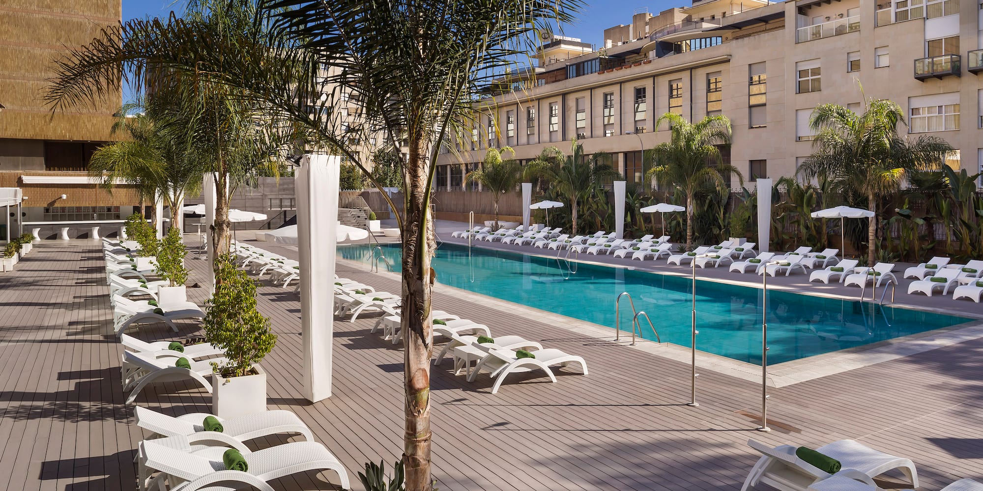 a pool with lounge chairs and palm trees