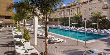 a pool with lounge chairs and palm trees