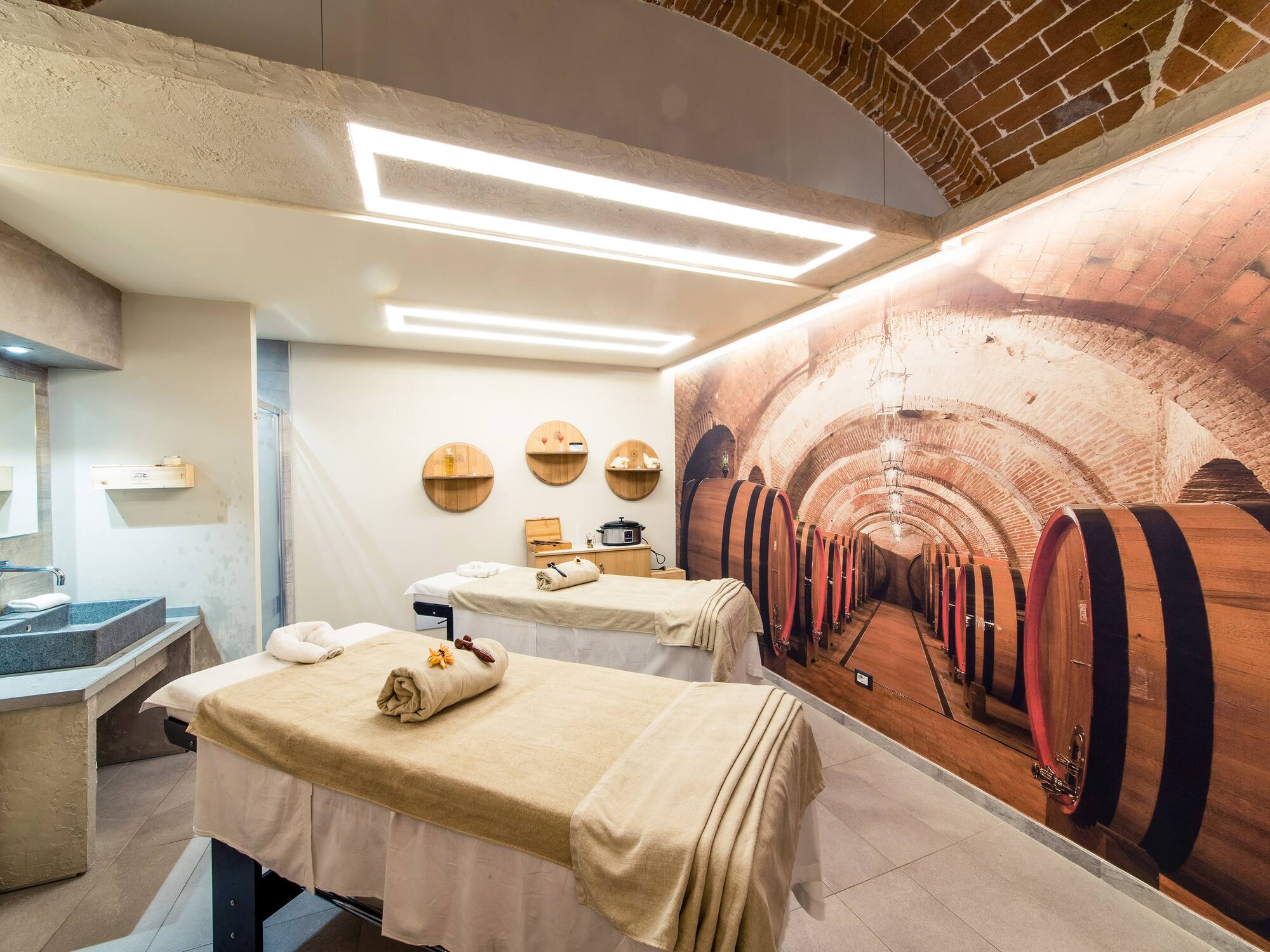 a room with beds and a mural of wine barrels
