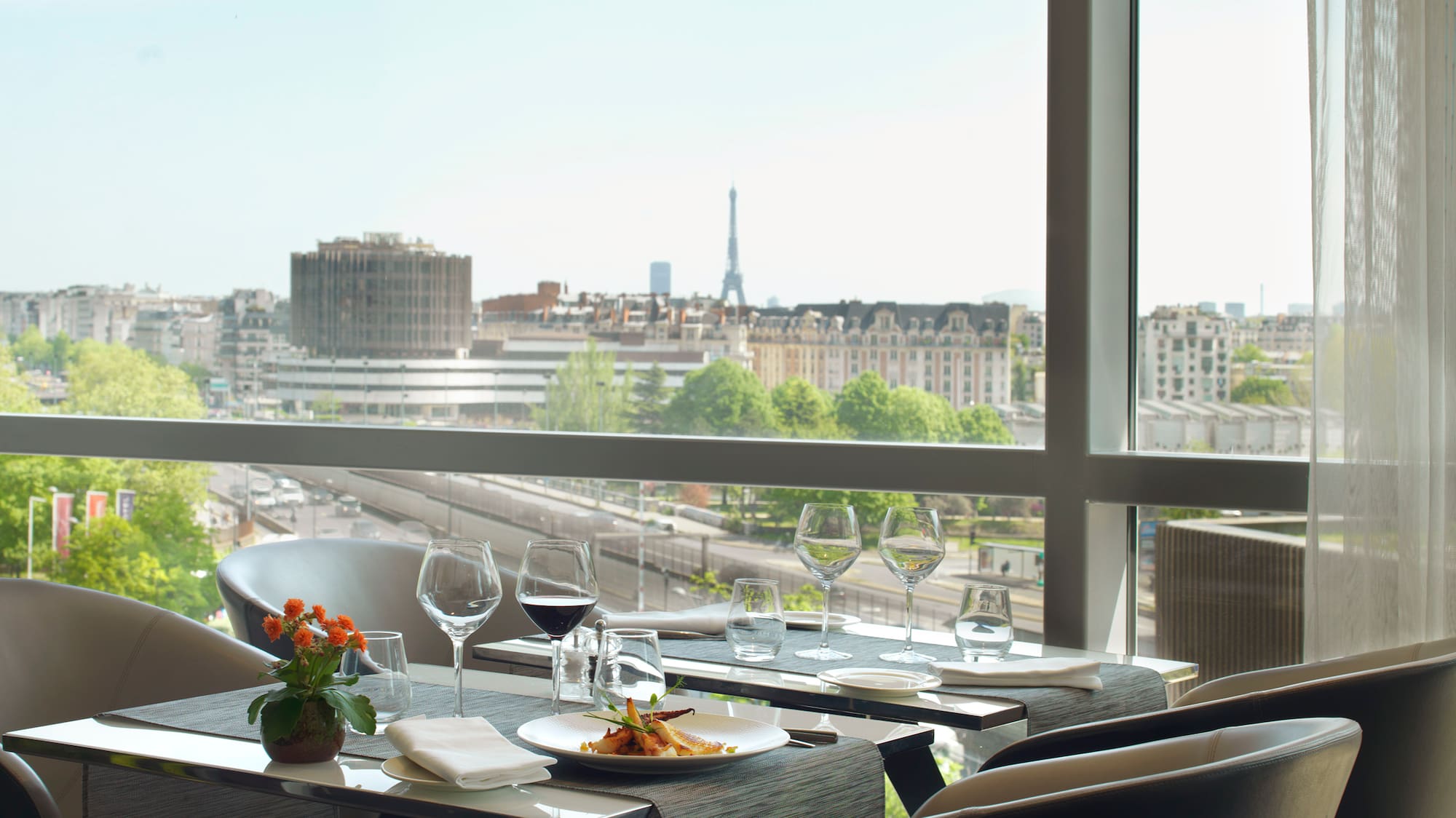 a table with plates and glasses on it and a view of a city