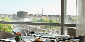 a table with plates and glasses on it and a view of a city