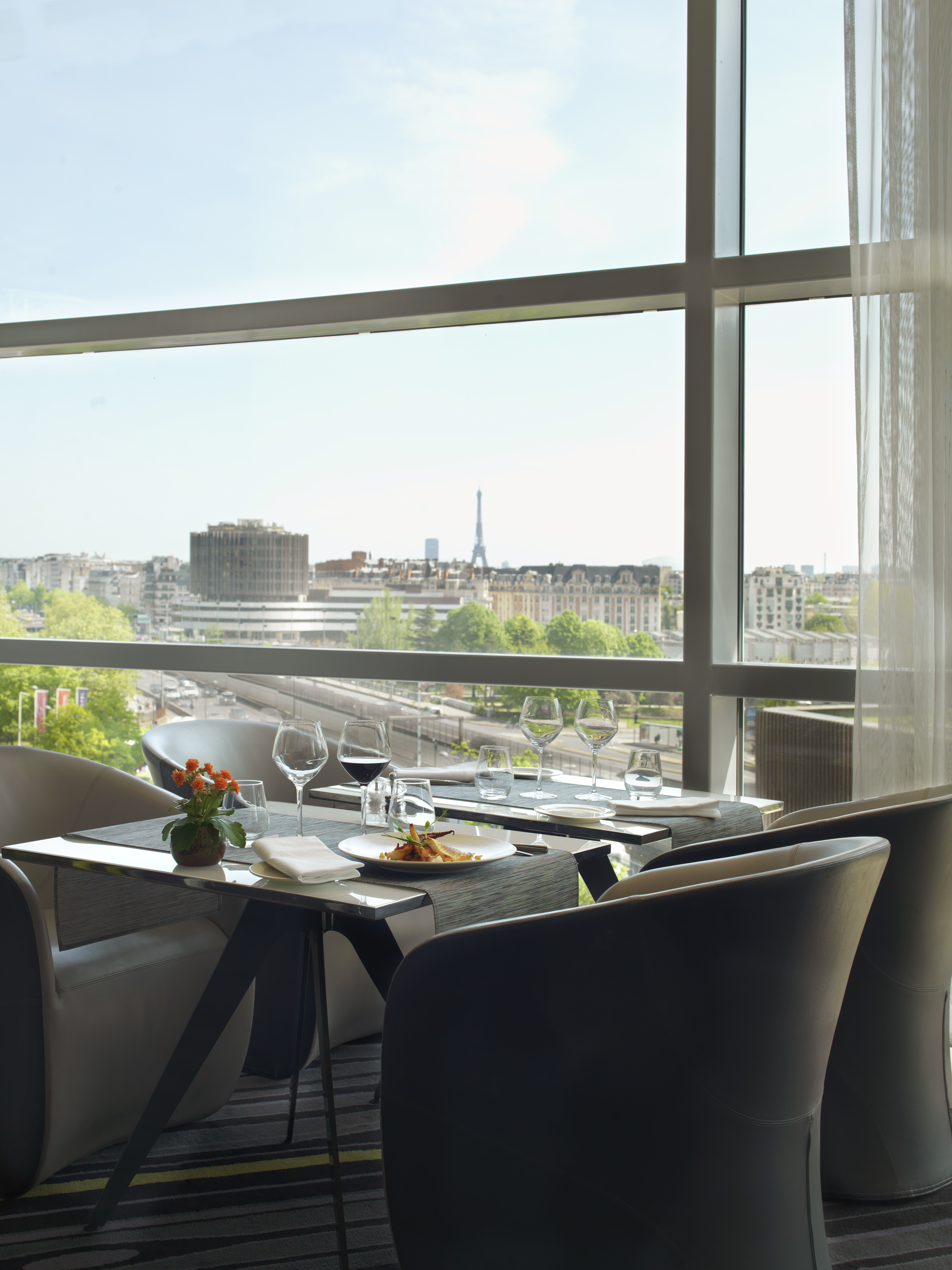 a table with plates and glasses on it and a view of a city