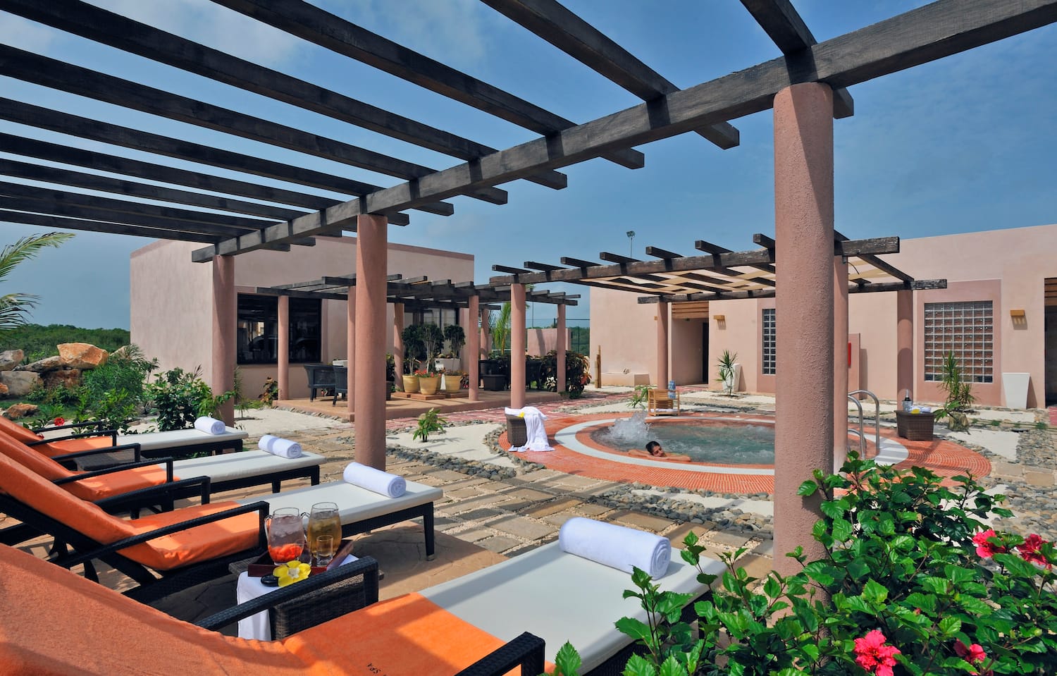 a pool with lounge chairs and a couple of people in the background