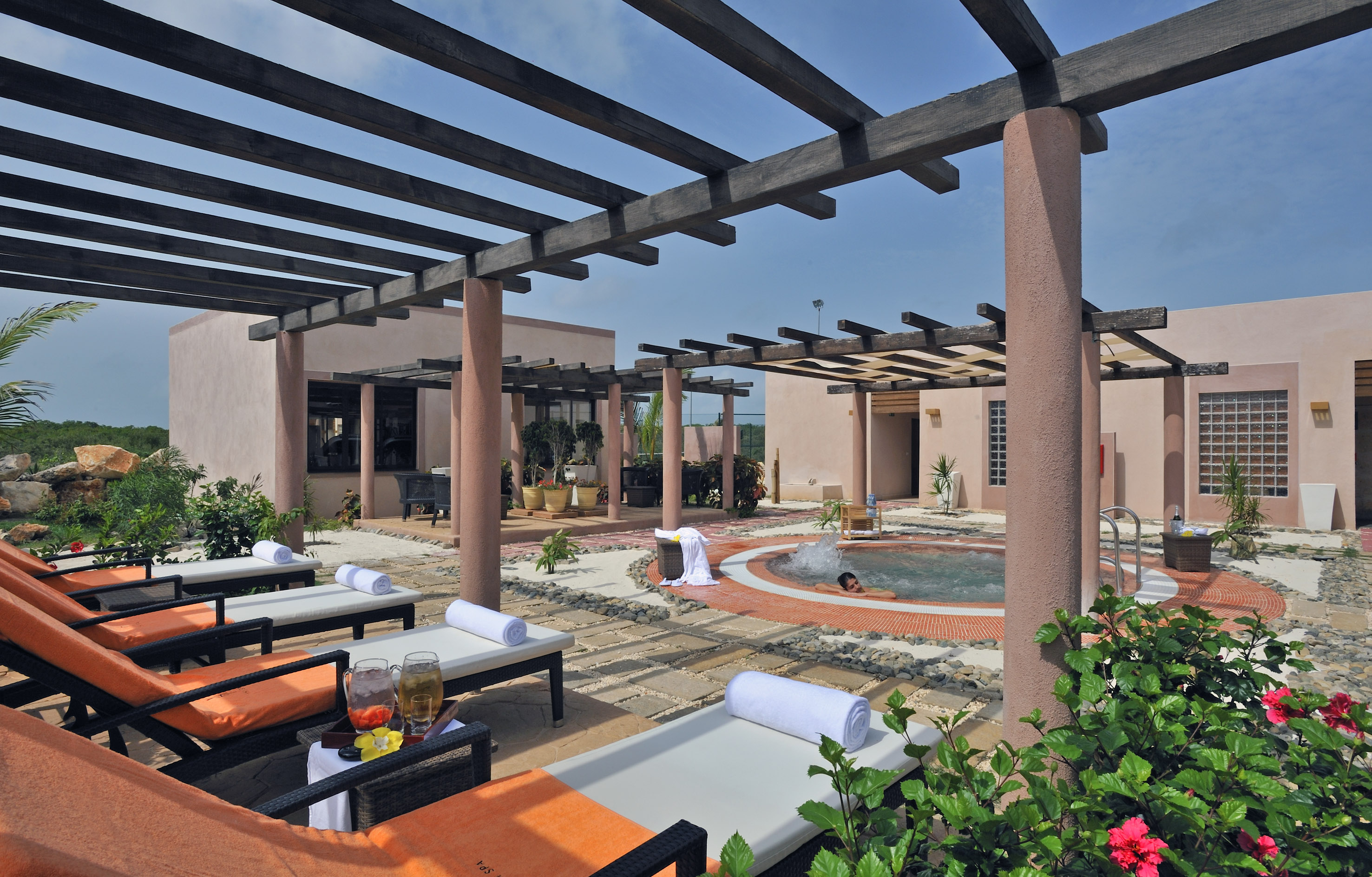 a pool with lounge chairs and a couple of people in the background