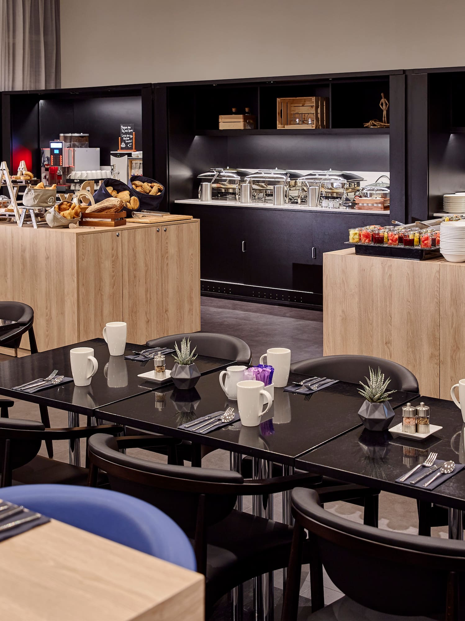 a room with black tables and blue chairs