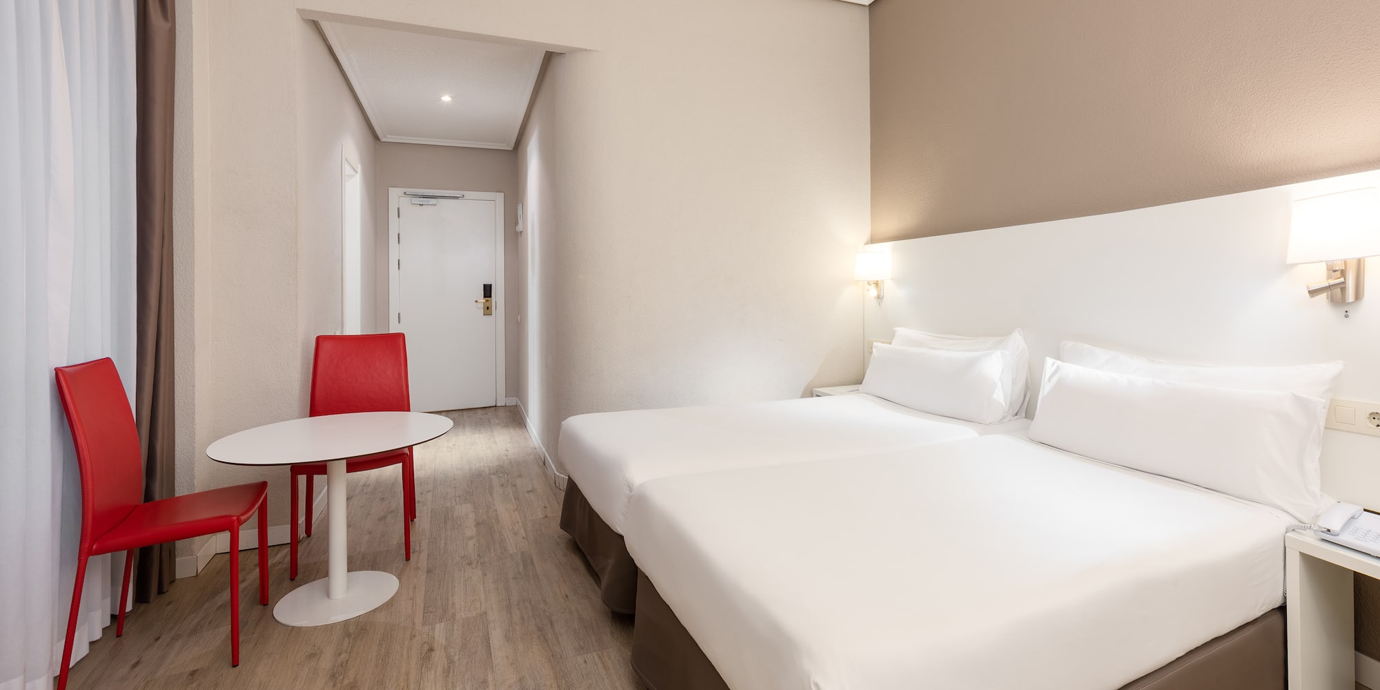 a room with two beds and a table