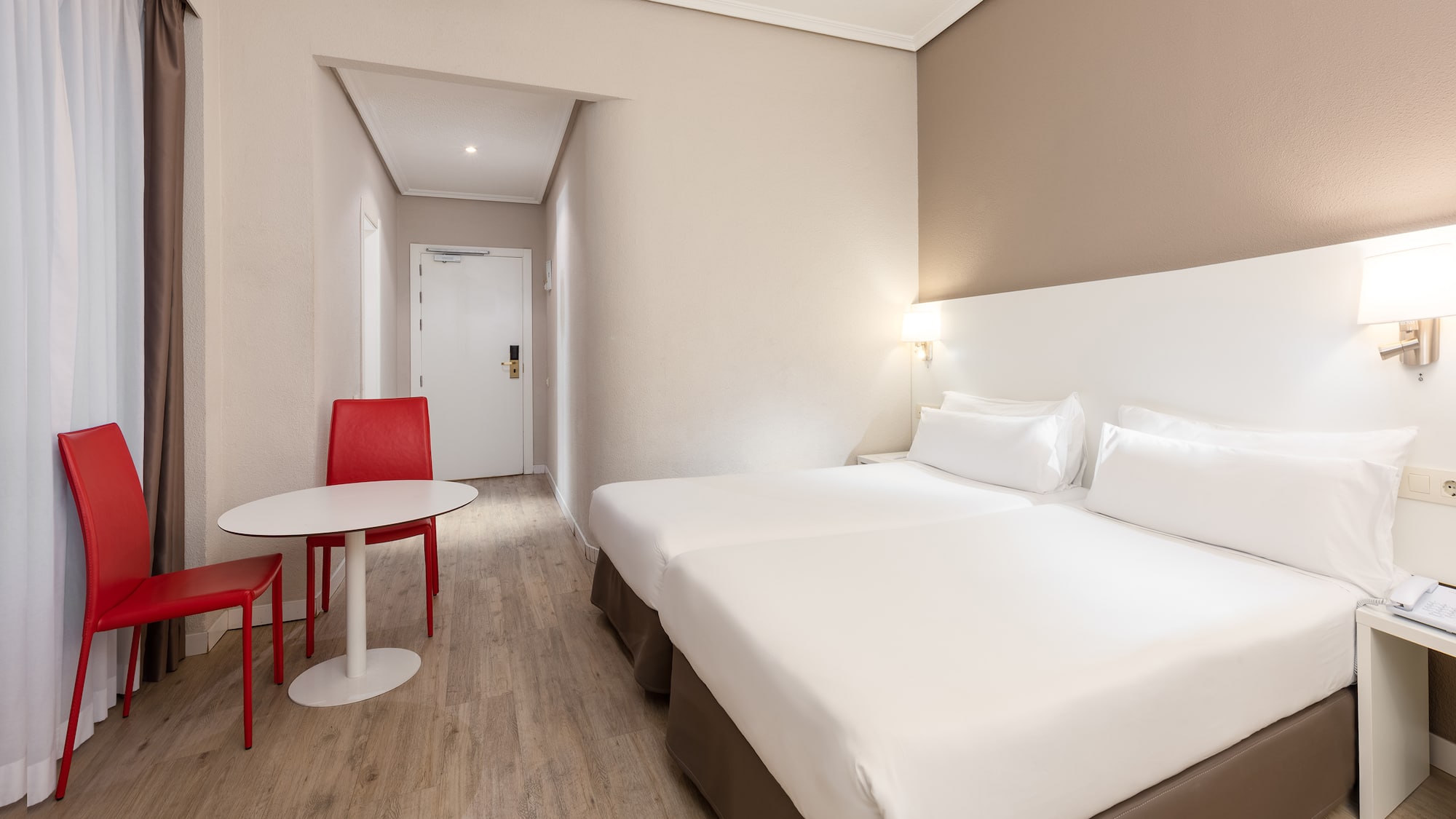 a room with two beds and a table