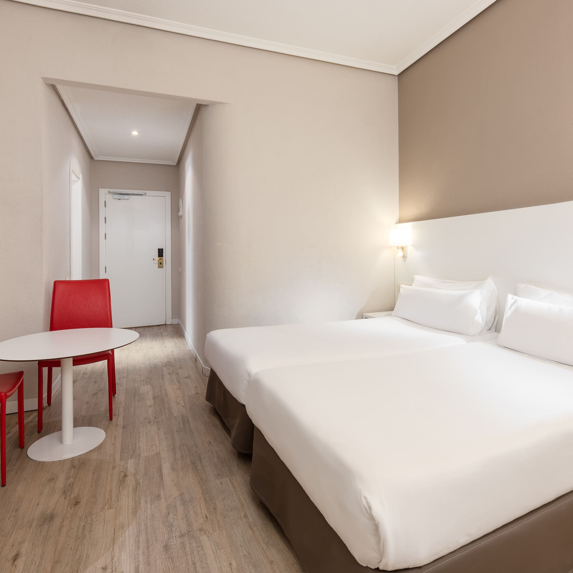 a room with two beds and a table