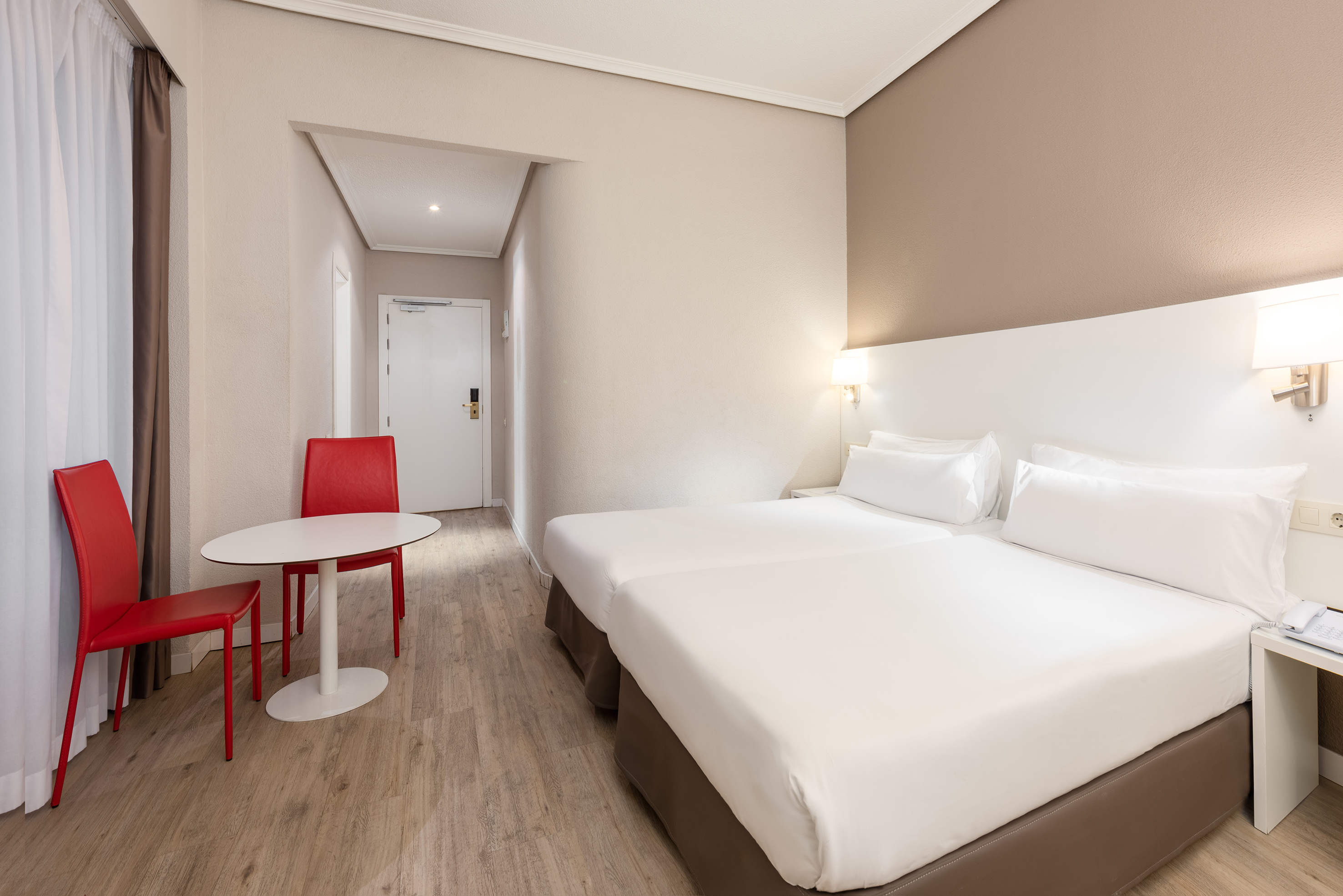 a room with two beds and a table