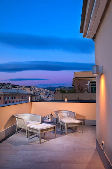 a patio with chairs and a table on a balcony
