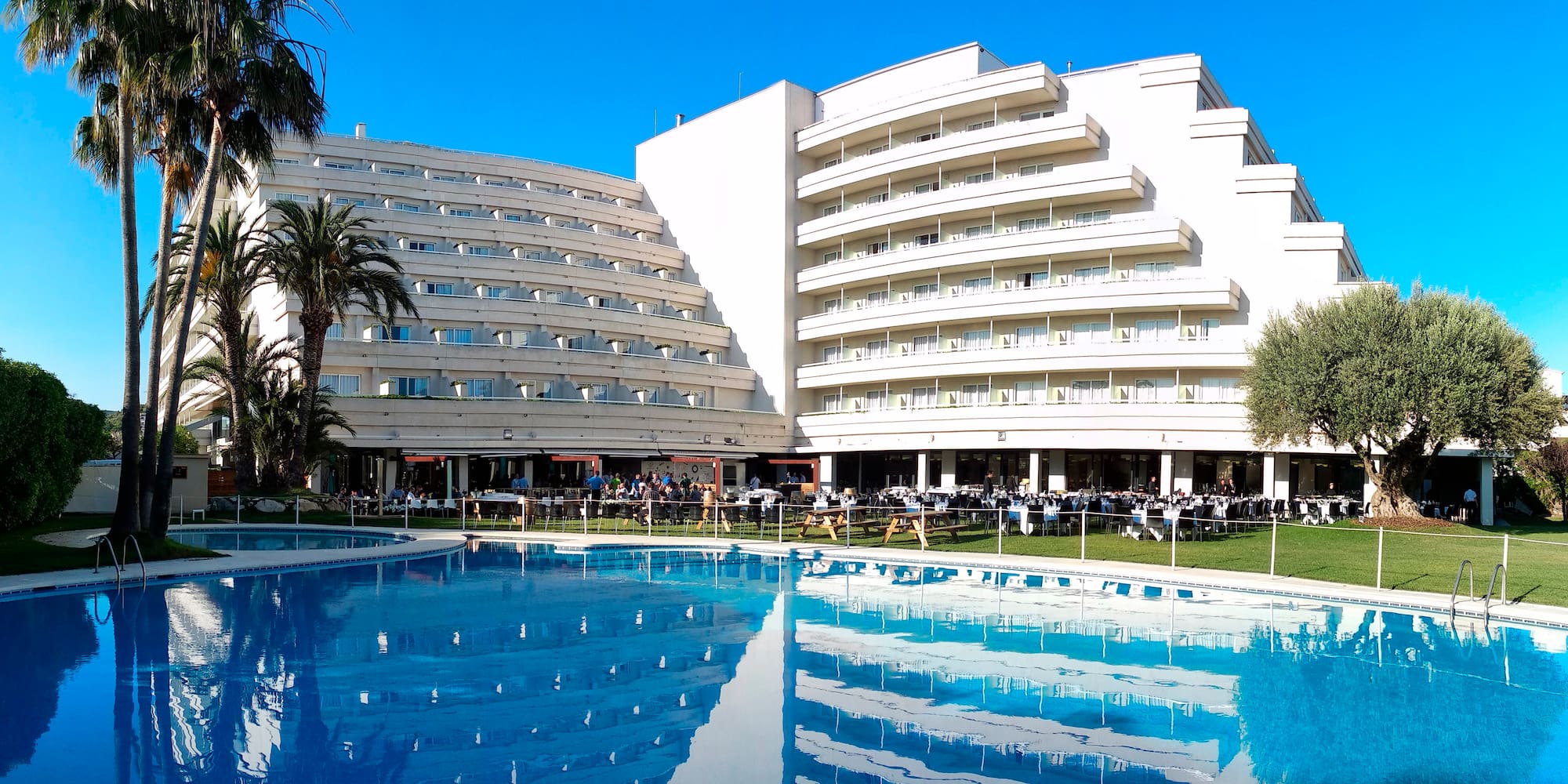 a large white building with a pool in front of it