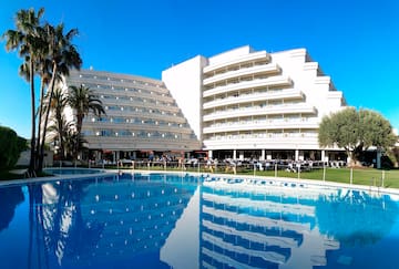 a large white building with a pool in front of it