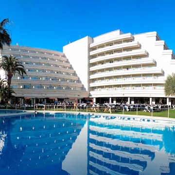 a large white building with a pool in front of it