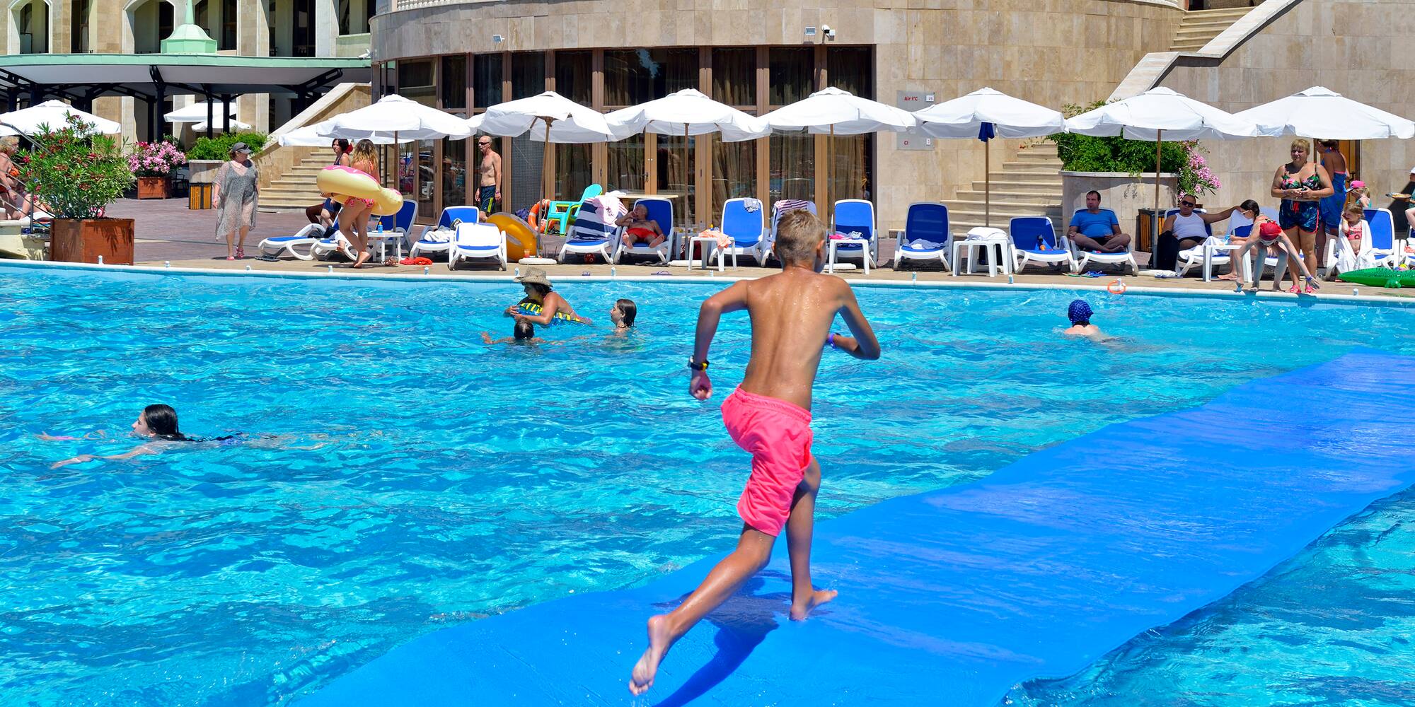 a boy on a blue mat in a pool