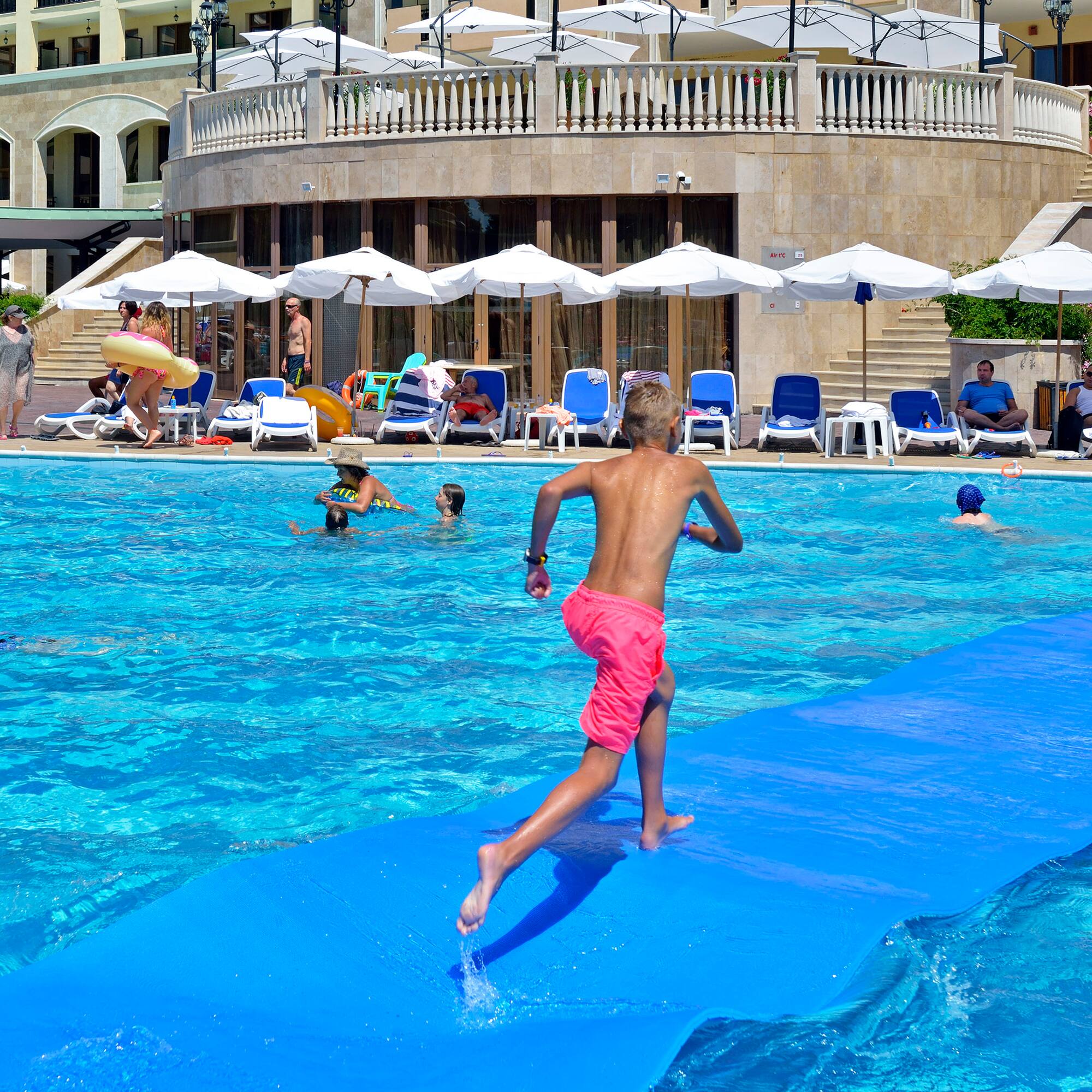 a boy on a blue mat in a pool