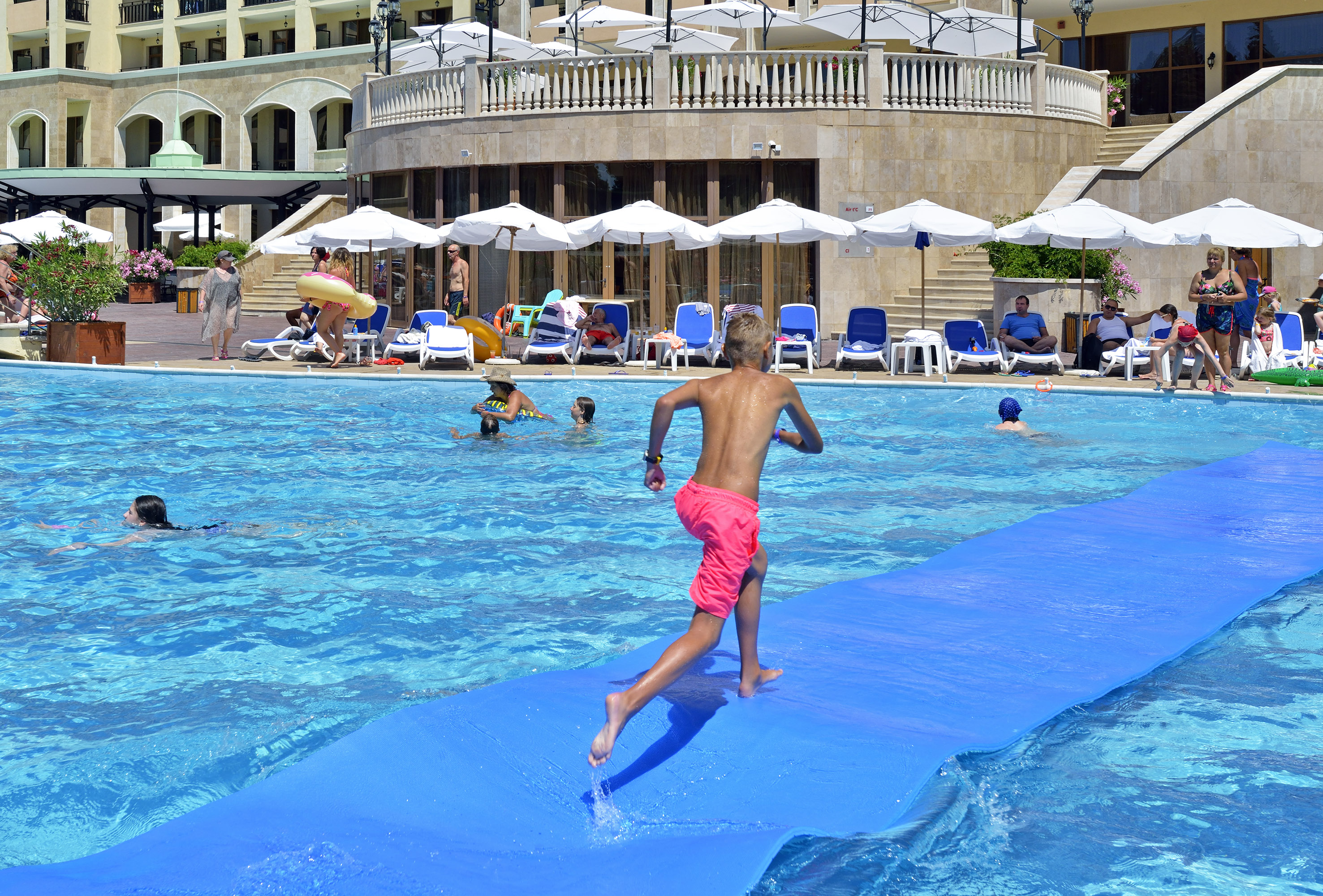 a boy on a blue mat in a pool