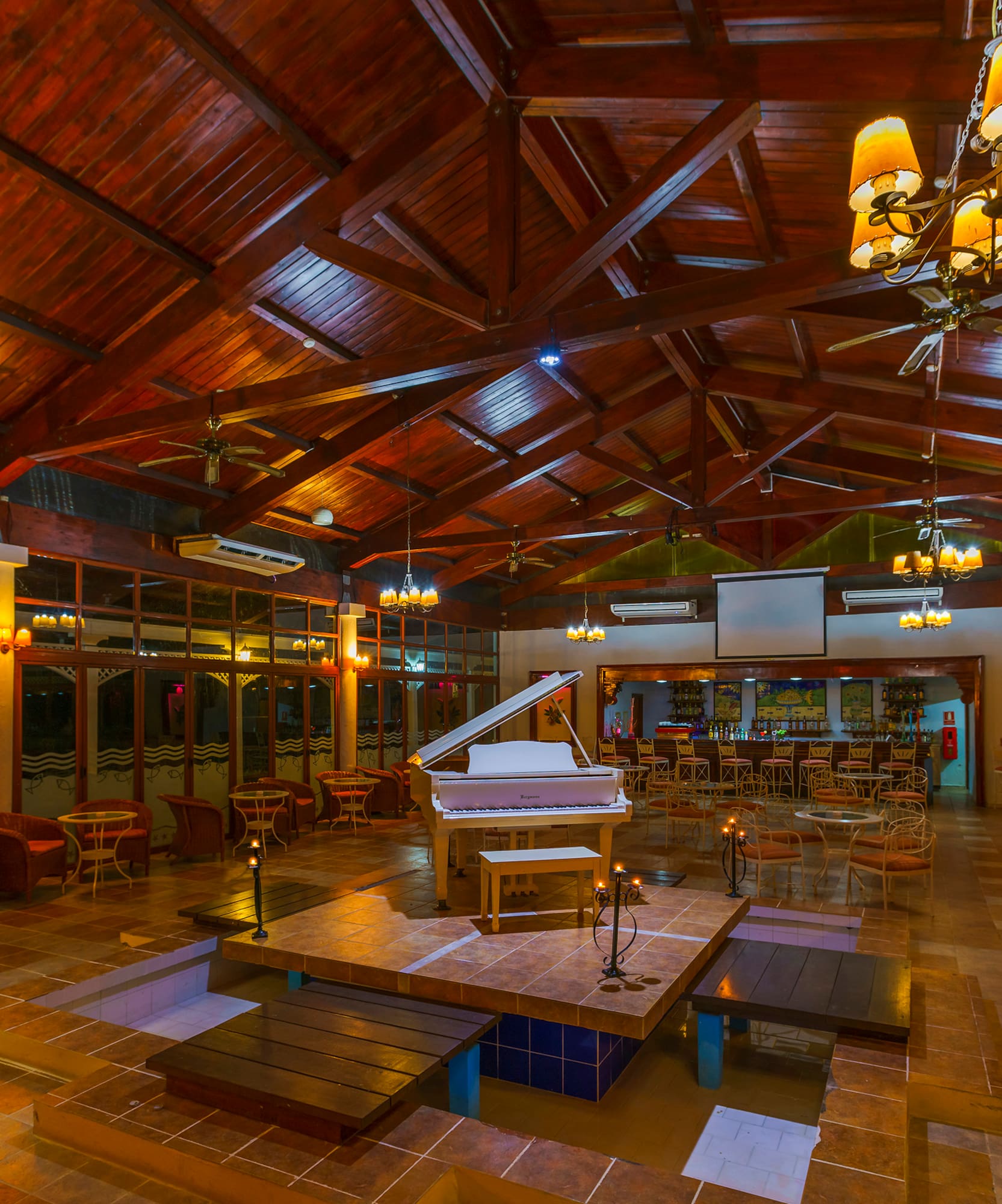 a room with a piano and tables and chairs